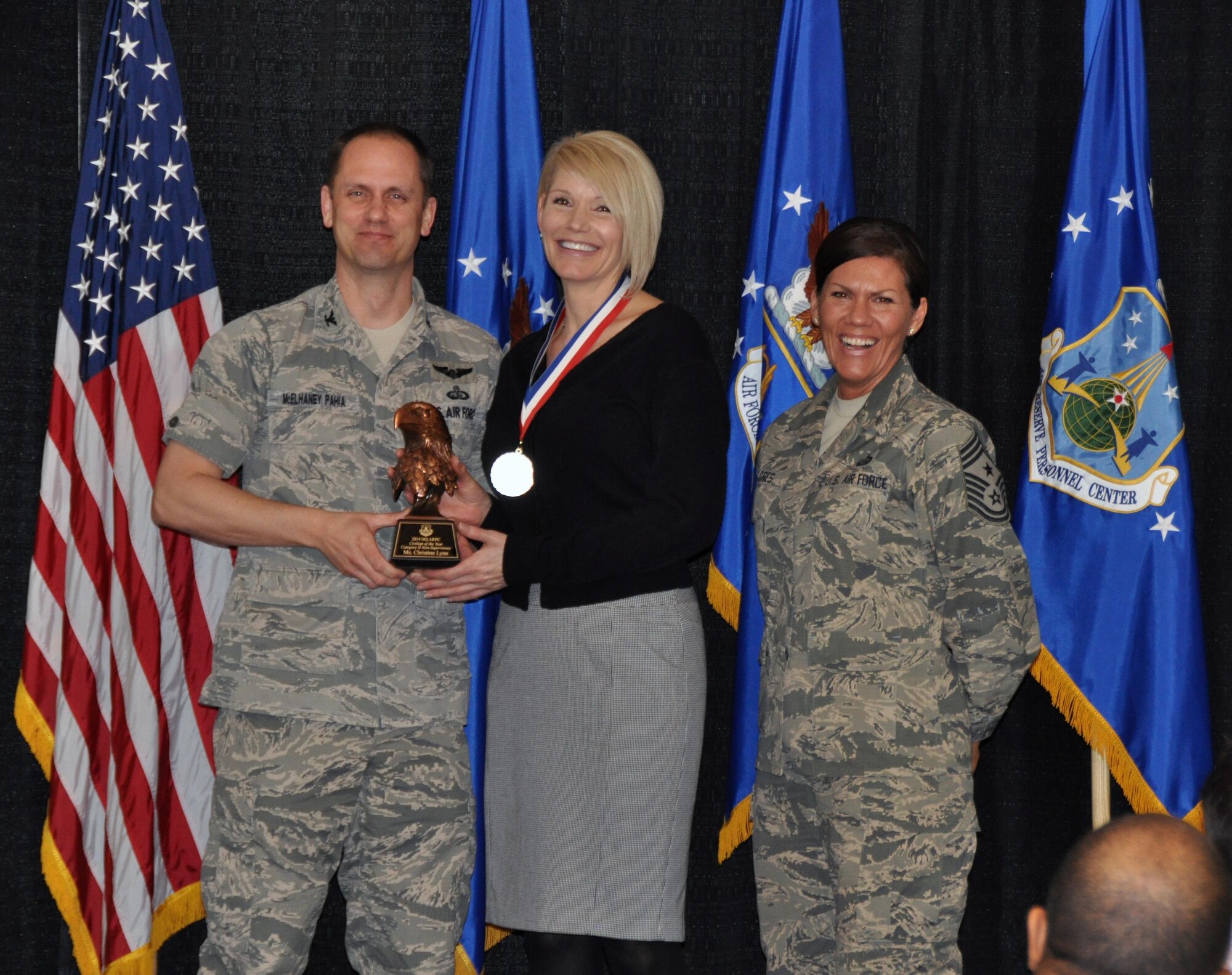 Col. Sean McElhaney Pahia, Air Reserve Personnel Center vice commander, and Chief Master Sgt. Ruthe Flores, ARPC command chief, present the Category II, Non-Supervisory Civilian of the Year award to Christine Lynn. McElhaney Pahia honored ARPC’s 2014 outstanding performers of the year as well as their A1 annual award winners at the Summit Conference and Event Center Feb. 24, 2015, in Denver. (U.S. Air Force photo/Tech. Sgt. Rob Hazelett)