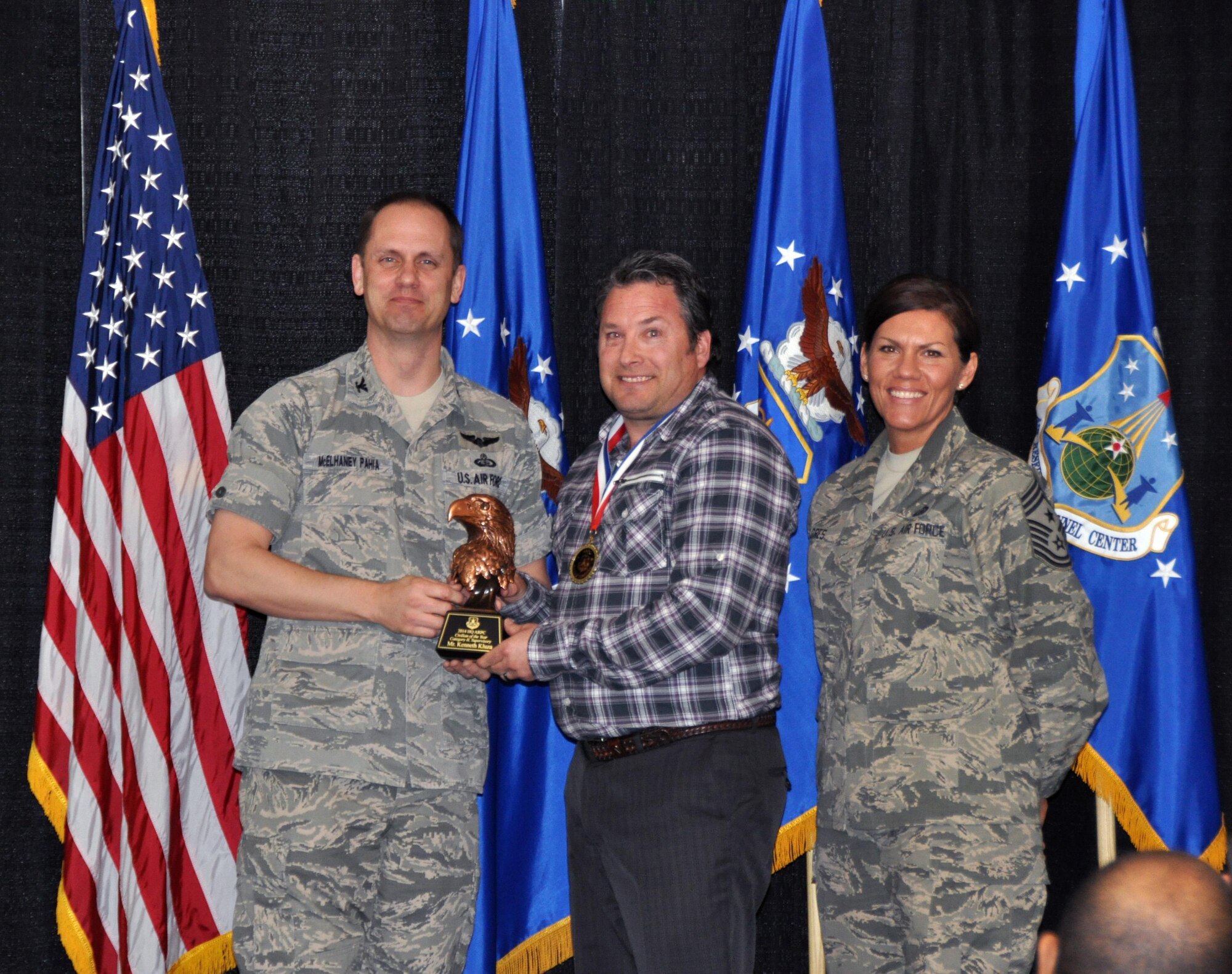 Col. Sean McElhaney Pahia, Air Reserve Personnel Center vice commander, and Chief Master Sgt. Ruthe Flores, ARPC command chief, present the A1 Civilian Manager of the Year, Operation Level award to Kenneth Kluza. McElhaney Pahia honored ARPC’s 2014 outstanding performers of the year as well as their A1 annual award winners at the Summit Conference and Event Center Feb. 24, 2015, in Denver. (U.S. Air Force photo/Tech. Sgt. Rob Hazelett)