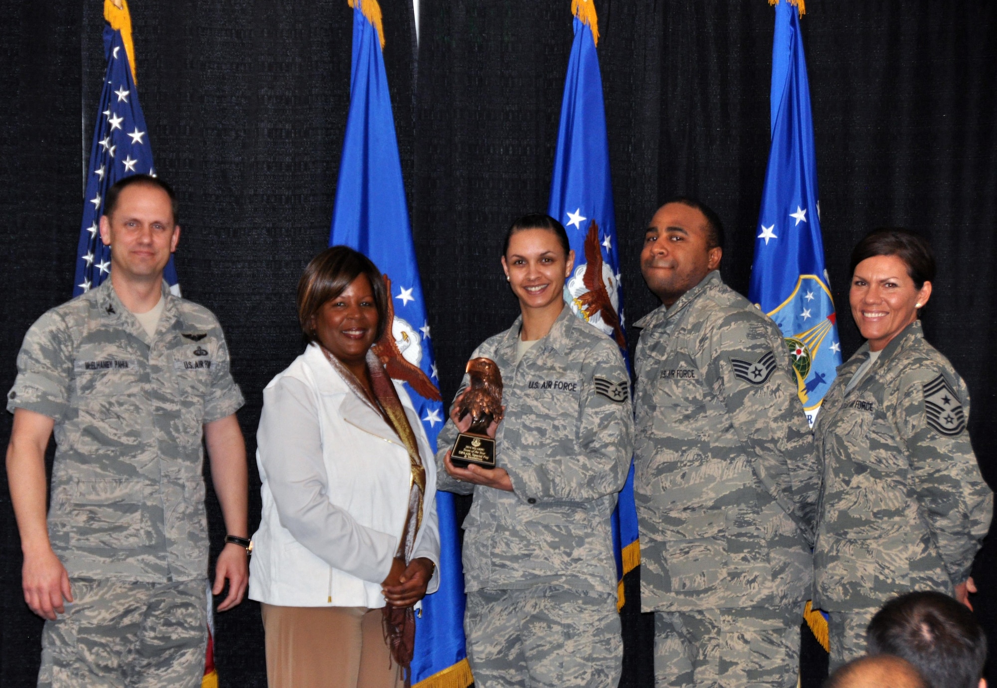 Col. Sean McElhaney Pahia, Air Reserve Personnel Center vice commander, Lisa Buckley, ARPC honorary commander, and Chief Master Sgt. Ruthe Flores, ARPC command chief, present the A1 Special Recognition Team and Program of the Year award to members from the Accessions Team. McElhaney Pahia honored ARPC’s 2014 outstanding performers of the year as well as their A1 annual award winners at the Summit Conference and Event Center Feb. 24, 2015, in Denver. (U.S. Air Force photo/Tech. Sgt. Rob Hazelett)