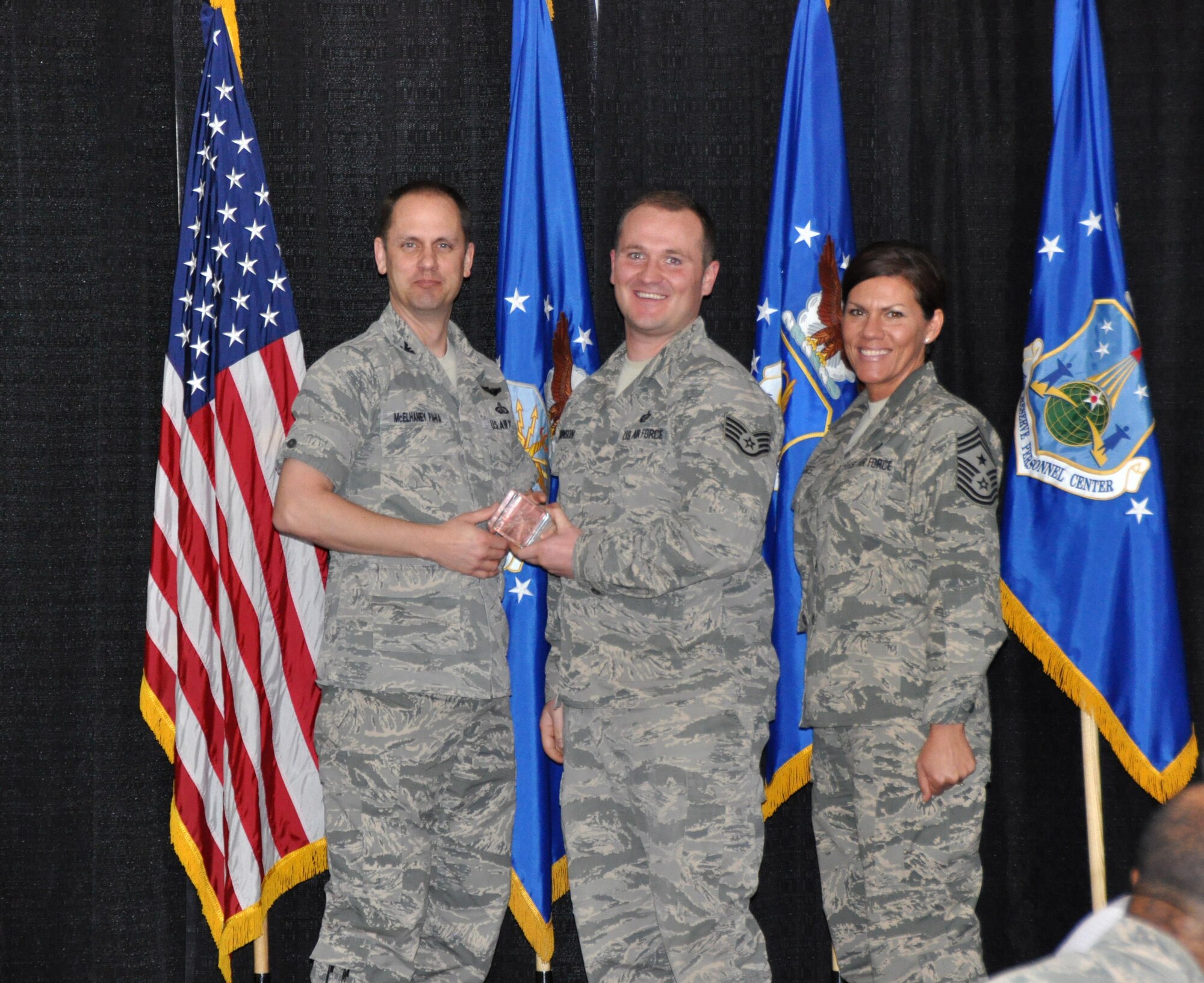 Col. Sean McElhaney Pahia, Air Reserve Personnel Center vice commander, and Chief Master Sgt. Ruthe Flores, ARPC command chief, present the Force Support Noncommissioned Officer of the Year award to Staff Sgt. Andrew Johnson. McElhaney Pahia honored ARPC’s 2014 outstanding performers of the year as well as their A1 annual award winners at the Summit Conference and Event Center Feb. 24, 2015, in Denver. (U.S. Air Force photo/Tech. Sgt. Rob Hazelett)