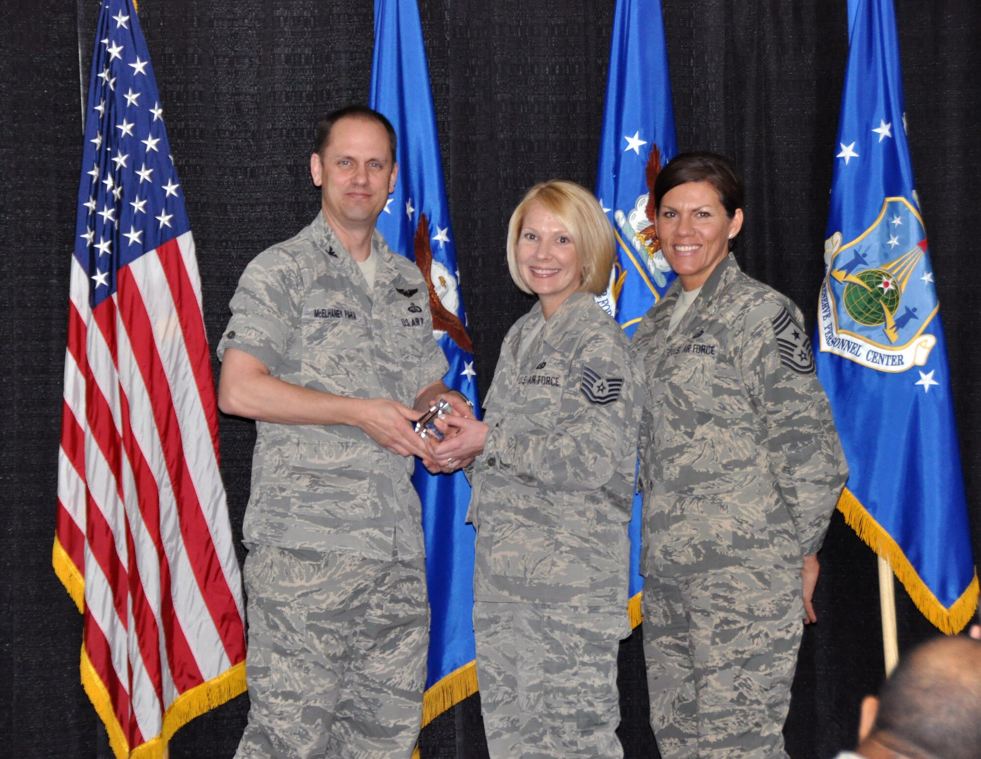 Col. Sean McElhaney Pahia, Air Reserve Personnel Center vice commander, and Chief Master Sgt. Ruthe Flores, ARPC command chief, present the Force Support Noncommissioned Officer of the Year, Air Reserve Component award to Tech. Sgt. Amy Szpak. McElhaney Pahia honored ARPC’s 2014 outstanding performers of the year as well as their A1 annual award winners at the Summit Conference and Event Center Feb. 24, 2015, in Denver. (U.S. Air Force photo/Tech. Sgt. Rob Hazelett)