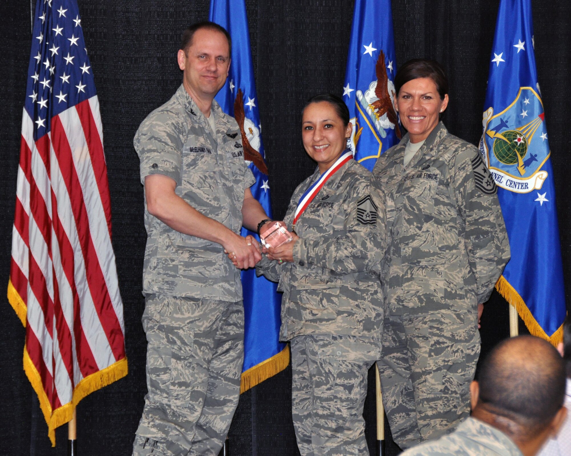 Col. Sean McElhaney Pahia, Air Reserve Personnel Center vice commander, and Chief Master Sgt. Ruthe Flores, ARPC command chief, present the Force Support Senior Noncommissioned Officer of the Year award to Master Sgt. Christina Hollingshead. McElhaney Pahia honored ARPC’s 2014 outstanding performers of the year as well as their A1 annual award winners at the Summit Conference and Event Center Feb. 24, 2015, in Denver. (U.S. Air Force photo/Tech. Sgt. Rob Hazelett)