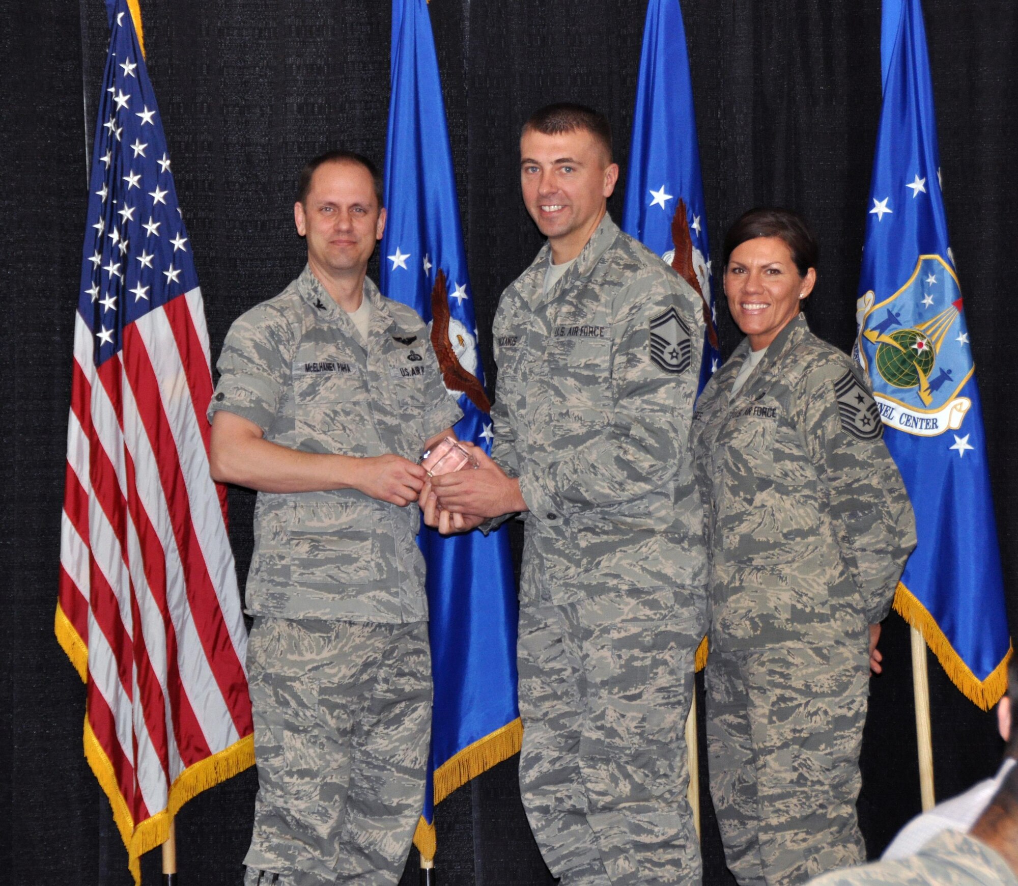 Col. Sean McElhaney Pahia, Air Reserve Personnel Center vice commander, and Chief Master Sgt. Ruthe Flores, ARPC command chief, present the Force Support Senior Noncommissioned Officer of the Year, Air Reserve Component award to Senior Master Sgt. Richard Mackanos, Jr. McElhaney Pahia honored ARPC’s 2014 outstanding performers of the year as well as their A1 annual award winners at the Summit Conference and Event Center Feb. 24, 2015, in Denver. (U.S. Air Force photo/Tech. Sgt. Rob Hazelett)