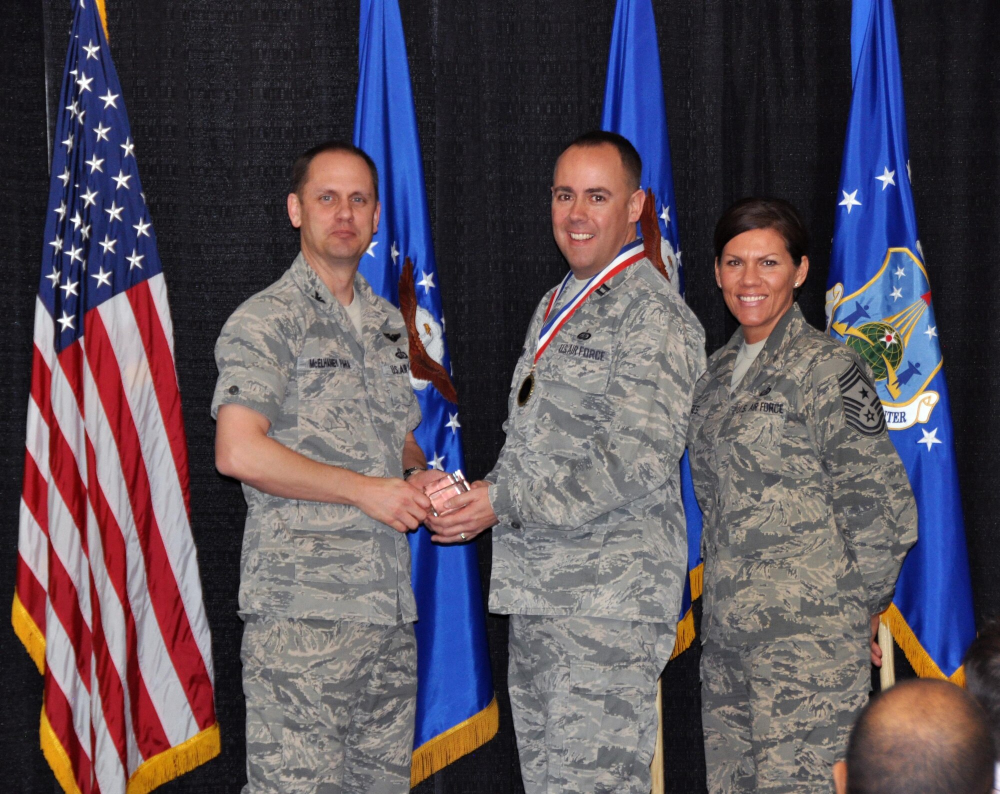 Col. Sean McElhaney Pahia, Air Reserve Personnel Center vice commander, and Chief Master Sgt. Ruthe Flores, ARPC command chief, present the Personnel Company Grade Officer of the Year Air Reserve Component award to Capt. Andrew Williams. McElhaney Pahia honored ARPC’s 2014 outstanding performers of the year as well as their A1 annual award winners at the Summit Conference and Event Center Feb. 24, 2015, in Denver. (U.S. Air Force photo/Tech. Sgt. Rob Hazelett)