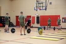 A Camp Allen High Intensity Tactical Training (HITT) instructor demonstrates proper form and leg placement to squat with weights during the HITT certification course at Hopkins Hall Gym at Camp Allen in Norfolk, Virginia. Feb 10. Marines learned proper techniques and forms to avoid injury while applying HITT to their daily physical training. The course teaches Marines how to properly and effectively instruct exercises associated with the three modules of HITT: Combat, Warrior and Athlete HITT.
