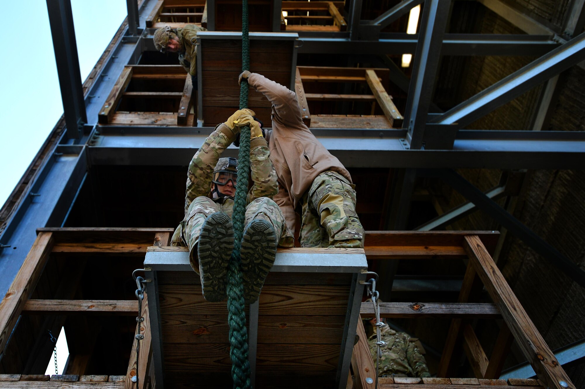 A U.S. Air Force Combat Control trainee assigned to Operating Location C, 342nd Training Squadron, works with instructors as he readies himself to fast-rope from a training tower, Feb. 13, 2015 at Pope Army Airfield, North Carolina. Fast-roping is a technique often used by Combat Control Airmen and other military members when descending a thick rope. It is useful for deploying troops from a helicopter in places where the helicopter itself cannot touch down. (U.S. Air Force photo by Staff Sgt. Kenny Holston)