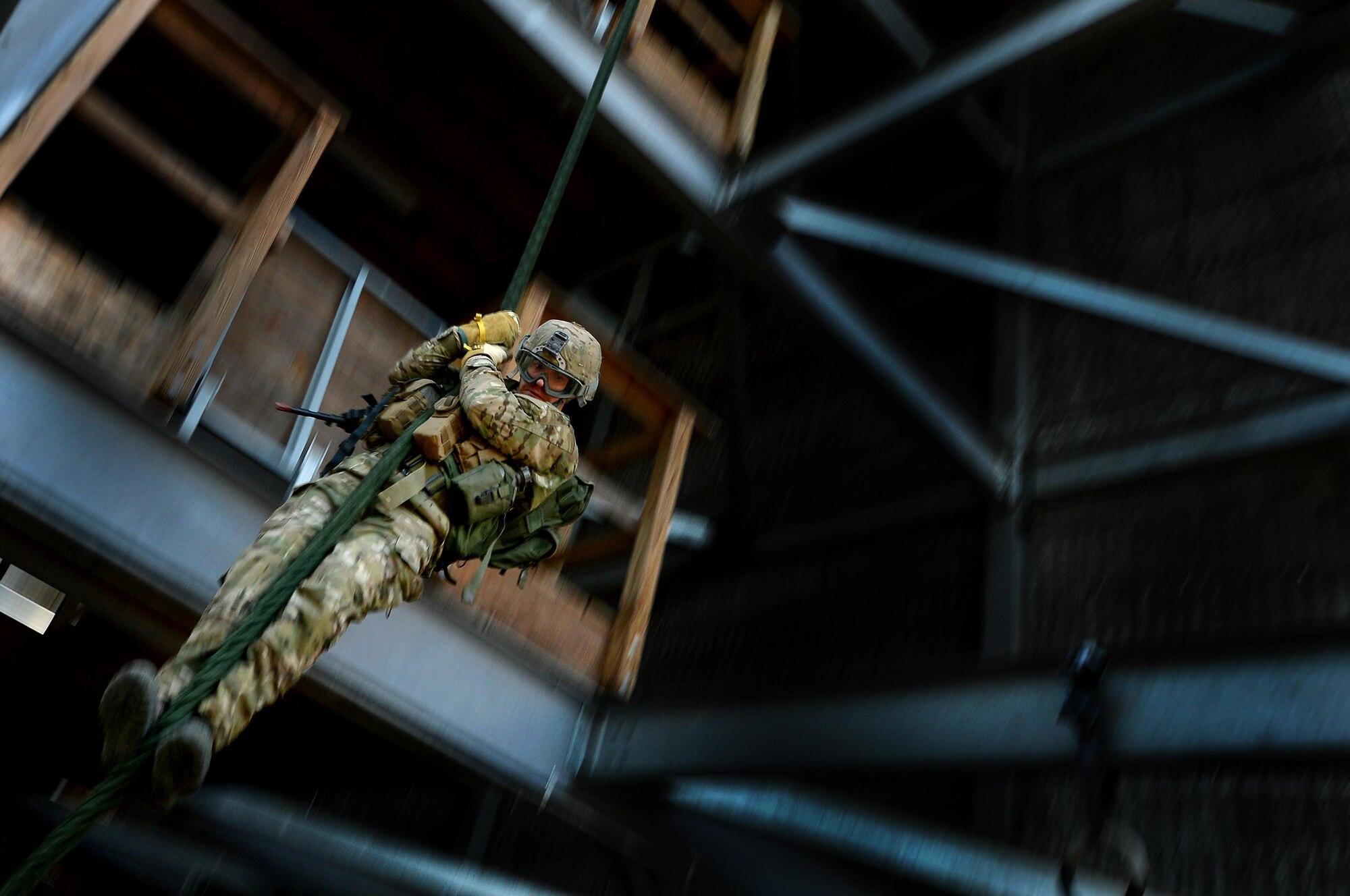 A U.S. Air Force Combat Control trainee assigned to Operating Location C, 342nd Training Squadron, hones his tactical skills while fast-roping from a training tower, Feb. 13, 2015 at Pope Army Airfield, North Carolina. The students begin with tower training to learn the skillset and build their confidence before fast-roping from helicopters. (U.S. Air Force photo by Staff Sgt. Kenny Holston) 