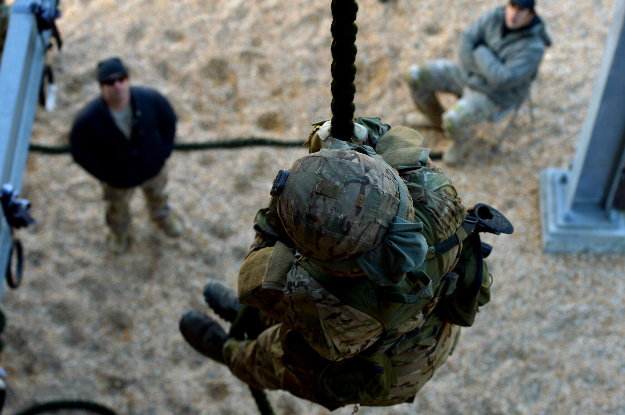 A U.S. Air Force Combat Control trainee assigned to Operating Location C, 342nd Training Squadron, is evaluated by two CCT instructors while fast-roping from a training tower, Feb. 13, 2015 at Pope Army Airfield, North Carolina. Students have to complete several phases of fast-rope training while being heavily evaluated before fast-roping from helicopters and other aircraft. Fast-roping allows Airmen and other military members to respond to crises as a quick reaction force, conduct missions requiring stealth tactics and board vessels while at sea. (U.S. Air Force photo by Staff Sgt. Kenny Holston)