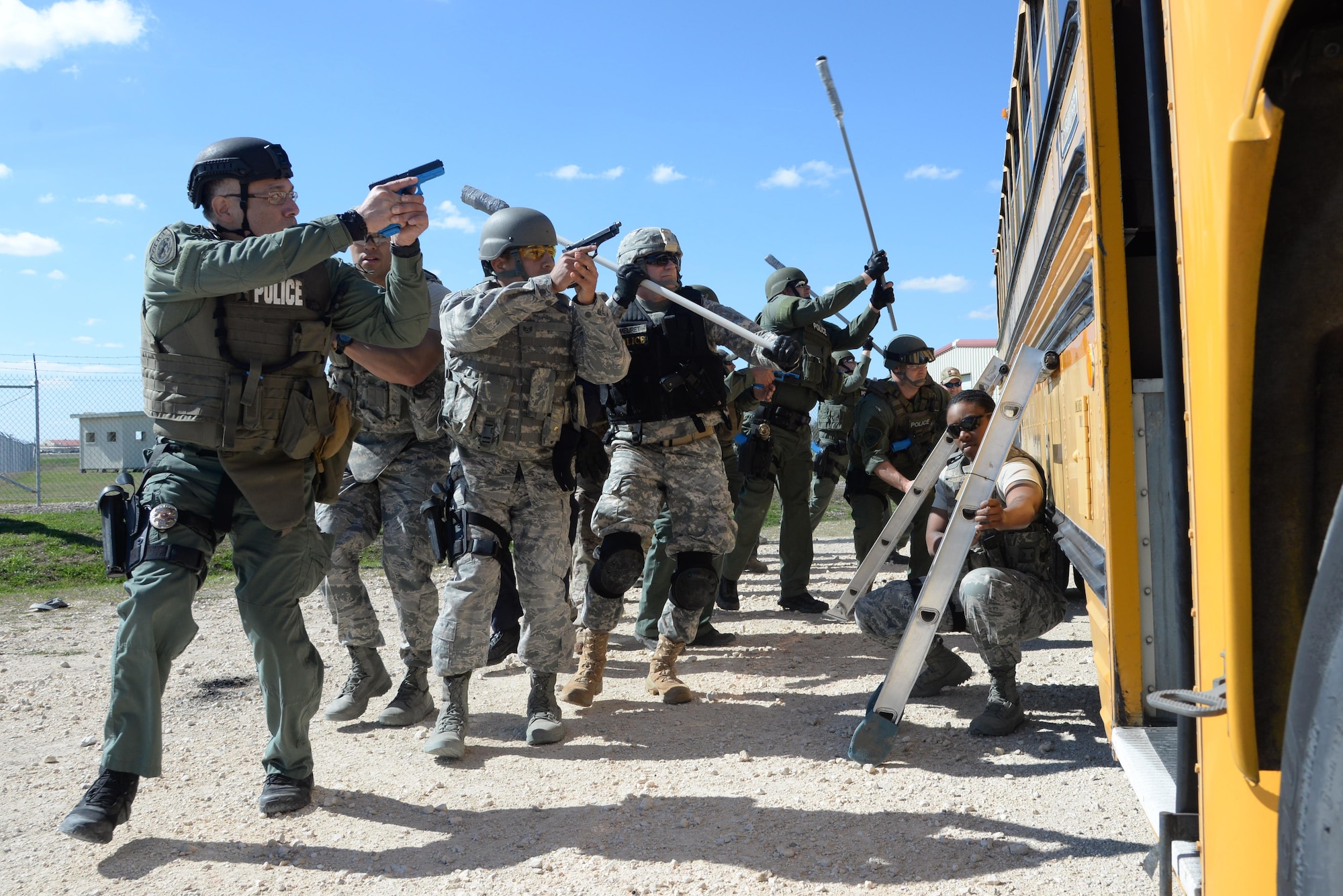 Members from the 902nd and 802nd Security forces Squadrons train with members of local police departments during a bus assault and hostage rescue exercise Feb. 19, 2015, at Joint Base San Antonio-Randolph, Texas. The local agencies involved in the exercise were from the cities of Live, Oak Universal City and Converse and the Judson Independent School District Police Departments. Security Forces and local police departments trained together to prepare for emergencies that require both military and civilian response efforts. (U.S. Air Force photo by Airman 1st Class Stormy Archer)