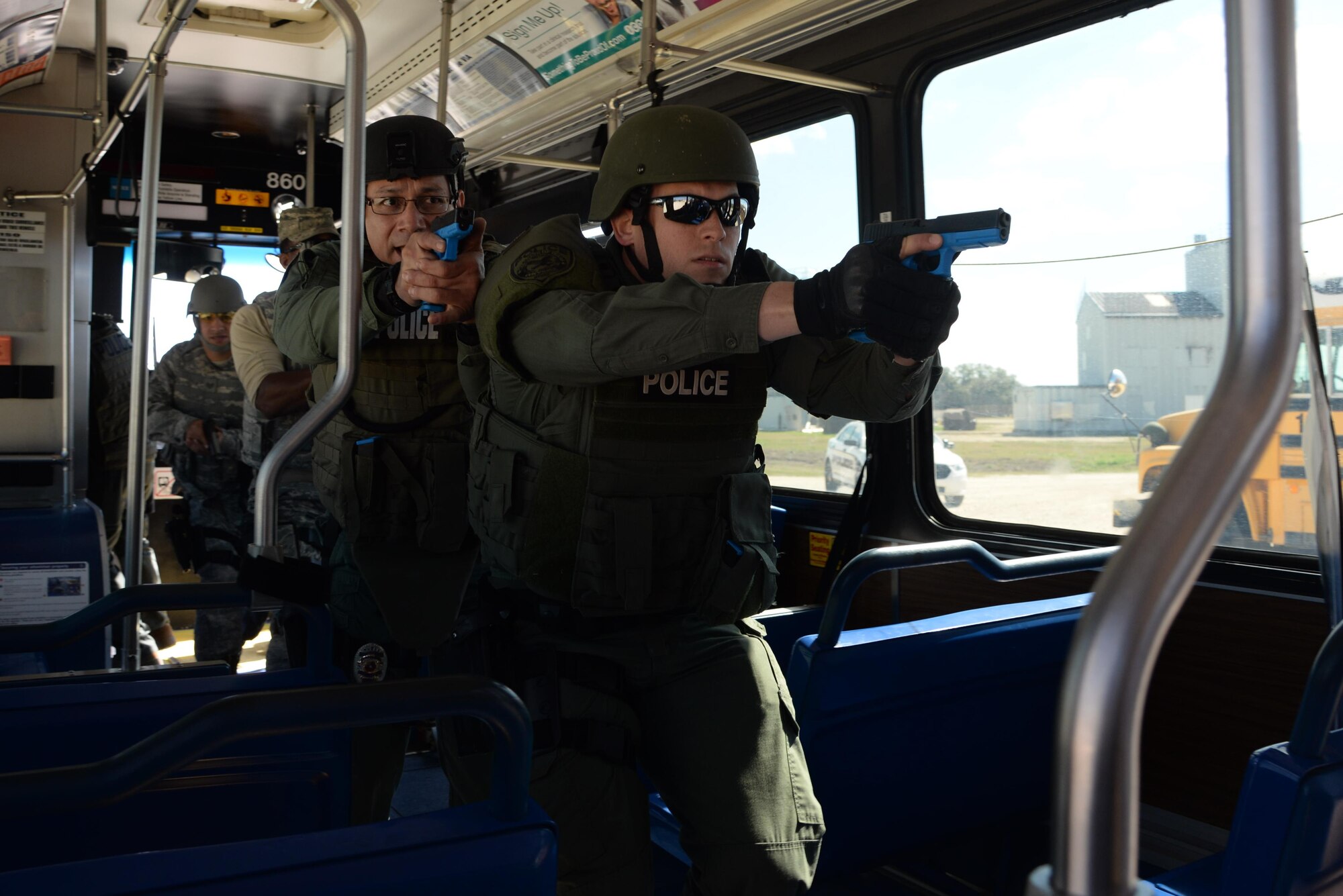 Officer John Salas, Judson Independent School District Police Department patrolman, and Officer Rich Radziski, Converse Police Department patrolman, board a city bus during a hostage rescue exercise Feb. 19, 2015 at Joint Base San Antonio-Randolph, Texas. The local agencies involved in the exercise were from the cities of Live, Oak Universal City and Converse and the Judson Independent School District Police Departments. Security Forces and local police departments trained together to prepare for emergencies that require both military and civilian response efforts. (U.S. Air Force photo by Airman 1st Class Stormy Archer)