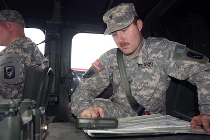 Missouri National Guard Spc. James Fetterhoff, of Headquarters and Headquarters Company, 3-135th Theater Aviation Battalion points to the digital compass on the Army’s defense advanced global positioning system receiver inside a Humvee during a recent navigation exercise in Laclede County.