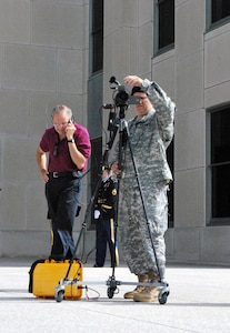 Army Sgt. Jon Haugen checks the video camera as Ken Lee, president of StreamQuik, calls back to the North Dakota National Guard’s visual information office to check the live video feed coming from the StreamCell device, which is the yellow case connected to the camera. The North Dakota National Guard used the new technology for the first time at the Capitol this month.