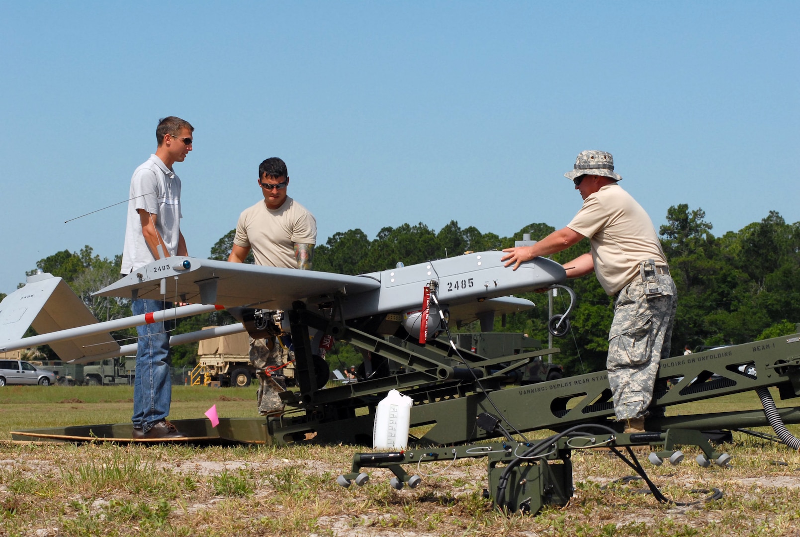 Soldiers from Company B, Special Troops Battalion, 53rd Infantry Brigade Combat Team load a Shadow unmanned aerial system onto a launcher prior to a training flight at Camp Blanding Joint Training Center.