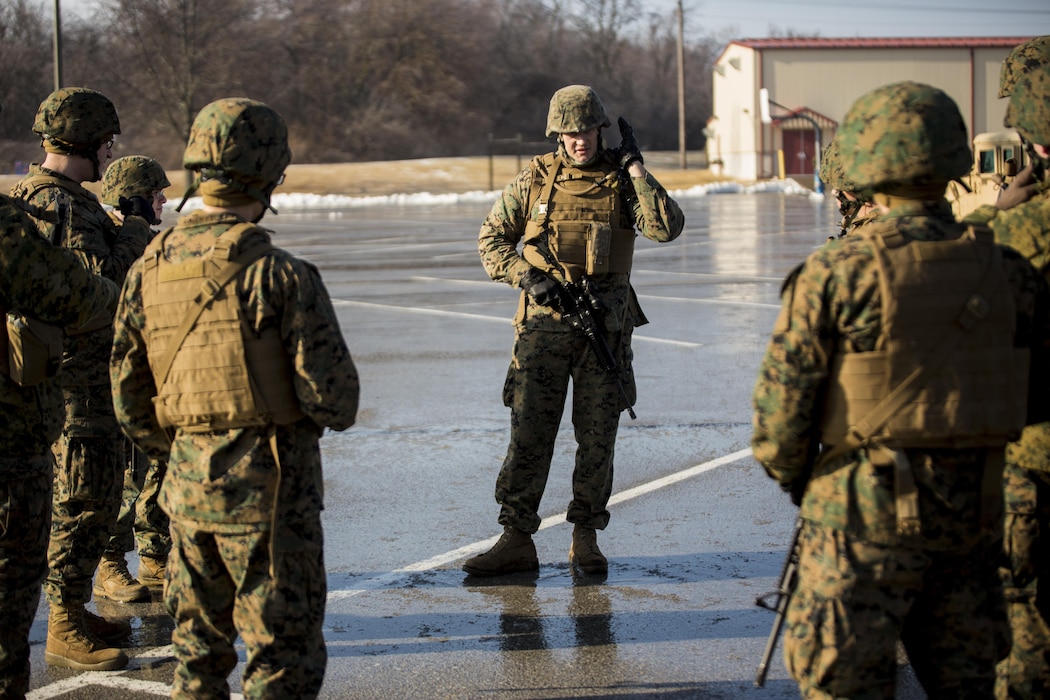 Sgt. John Duwe (center), a data network specialist with the Combat Logistics Regiment 4, 4th Marine Logistics Group, reviews basic hand and arm signals before he takes his platoon on a patrol during the Marine Expeditionary Force Exercise in Kansas City, Mo, Feb. 22, 2015. Duwe was the acting platoon leader in a guard force during the exercise with I MEF. The exercise enabled Marines to improve interoperability between the active and Reserve component, while preparing them with a realistic training environment at the force level.