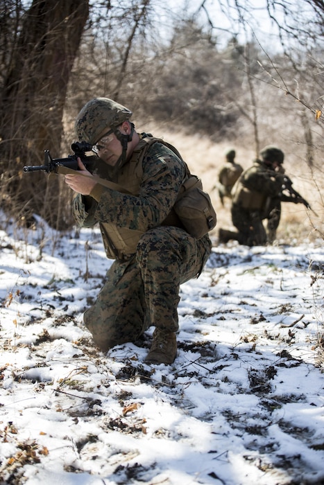 Cpl. Joseph Howell, a tactical switching operator with Combat Logistics Regiment 4, 4th Marine Logistics Group, kneels down and takes account of his surroundings on a patrol during the Marine Expeditionary Force Exercise in Kansas City, Mo, Feb. 22, 2015. Howell was part of the acting guard force during the exercise with I MEF. The exercise enabled Marines to improve interoperability between the active and Reserve component, while preparing them with a realistic training environment at the force level. 