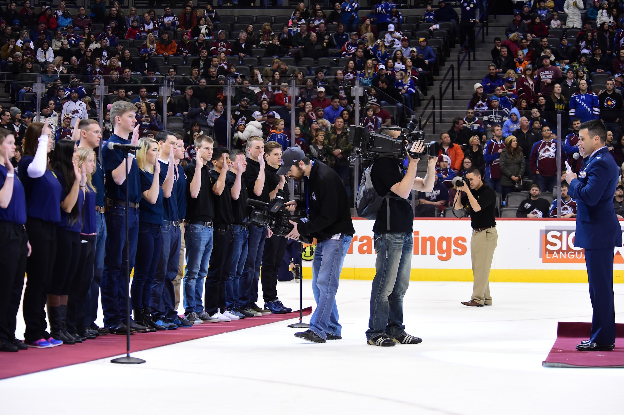 Col. John Wagner, 460th Space Wing commander, administers the Oath of Enlistment to military recruits Feb. 22, 2015, at the Pepsi Center in Denver.  Eighteen military recruits took the Oath of Enlistment during the second intermission of the game. (U.S. Air Force photo by Airman 1st Class Luke W. Nowakowski/Released)