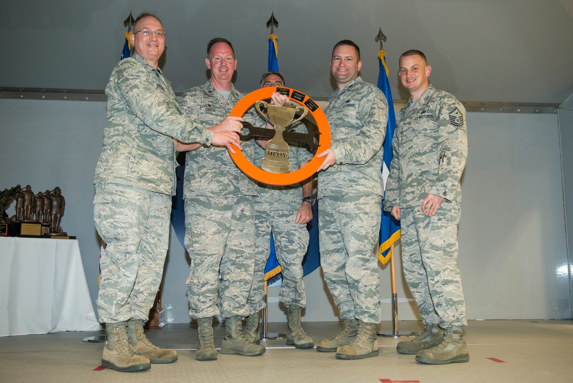 U.S. Air Force Col. Jeffrey Decker, left, 23d Maintenance Group commander, presents the Maintenance Professional of the Year sports day trophy to the 23d Equipment Maintenance Squadron during the 2015 MPOY awards ceremony Feb. 20, 2015, at Moody Air Force Base, Ga. The 23d MXG participated in many sports throughout the day, and the 23d EMS was declared the overall winner. (U.S. Air Force photo by Airman 1st Class Dillian Bamman/Released)