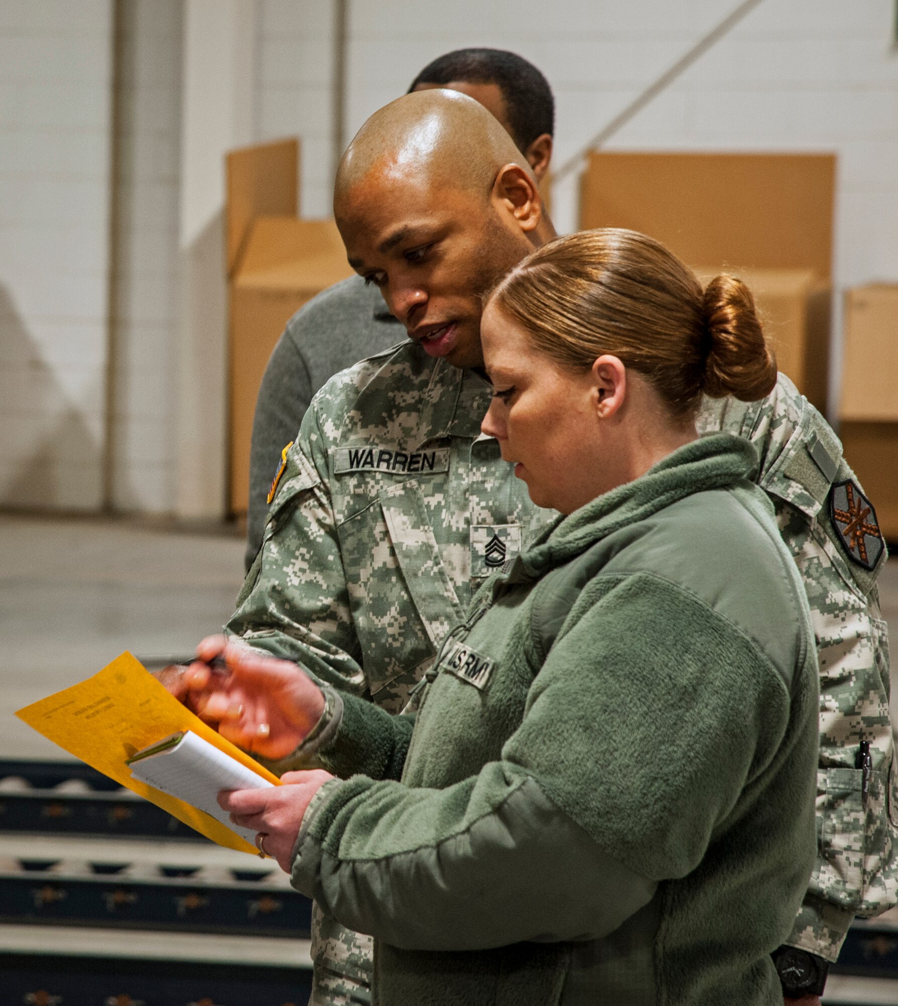 Army Sgt. First Class Leroy Warren, Arrival Departure Airfield Control Group NCO in charge, and Army Sgt. Amber Johnson, Federal Emergency Management Agency, discuss calculations of the weight of a truck during a joint exercise at Joint Base McGuire-Dix-Lakehurst, N.J., Feb. 12, 2015. Mobility specialists comprised of Army, Air Force and FEMA personnel came together to review policies and practices in the event airlift is needed to support a national emergency or crisis. (U.S. Air Force photo by Staff Sgt. Scott Saldukas/Released)