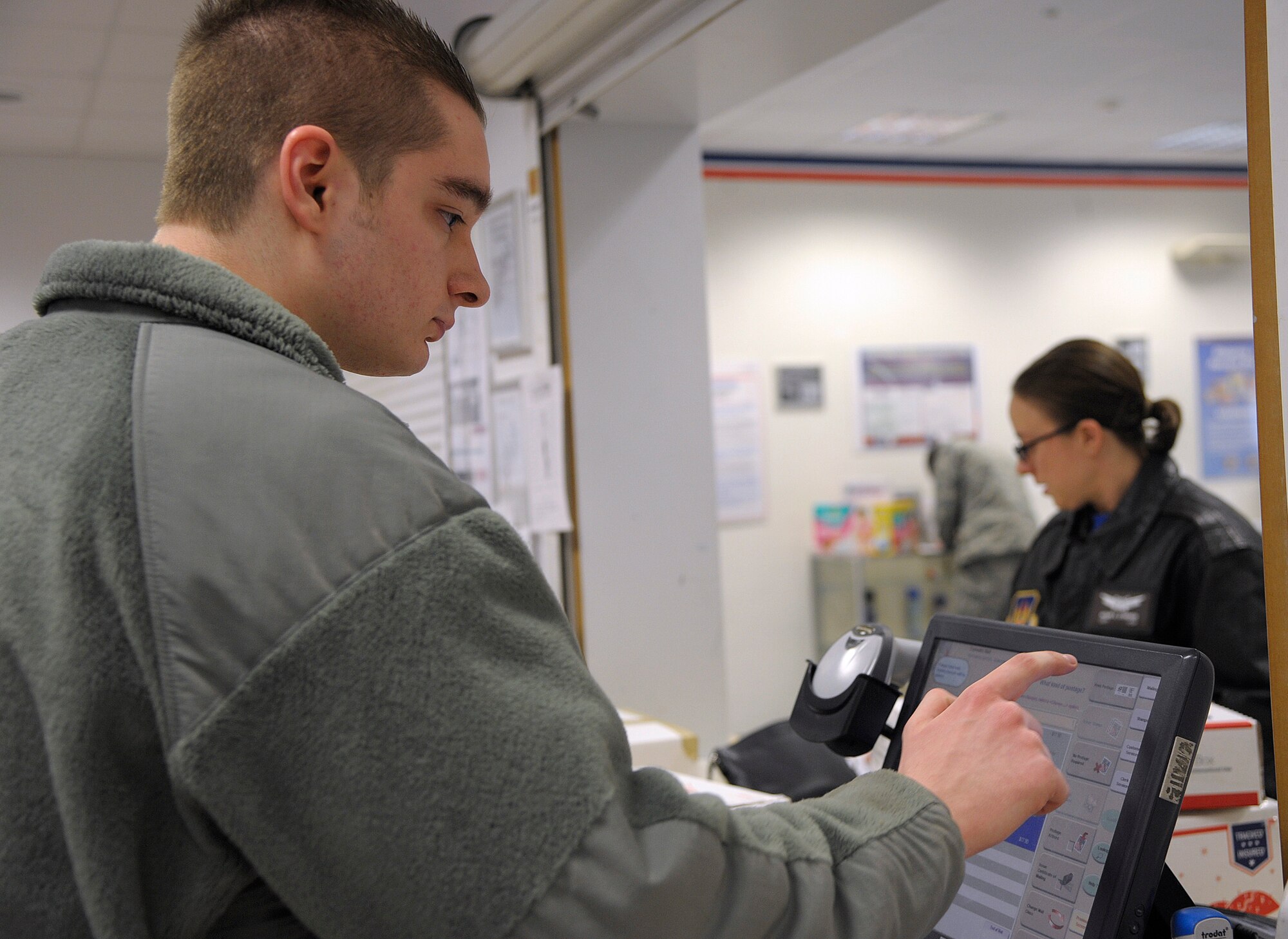 Airman 1st Class Ken Mozillo, 86th Communications Squadron postal specialist, helps a customer mail a package, Feb. 13, 2015 at Ramstein Air Base, Germany. The 86th CS postal specialists generate approximately $4 million annually, serving members of the Kaiserslautern Military Community. (U.S. Air Force photo/Senior Airman Timothy Moore)