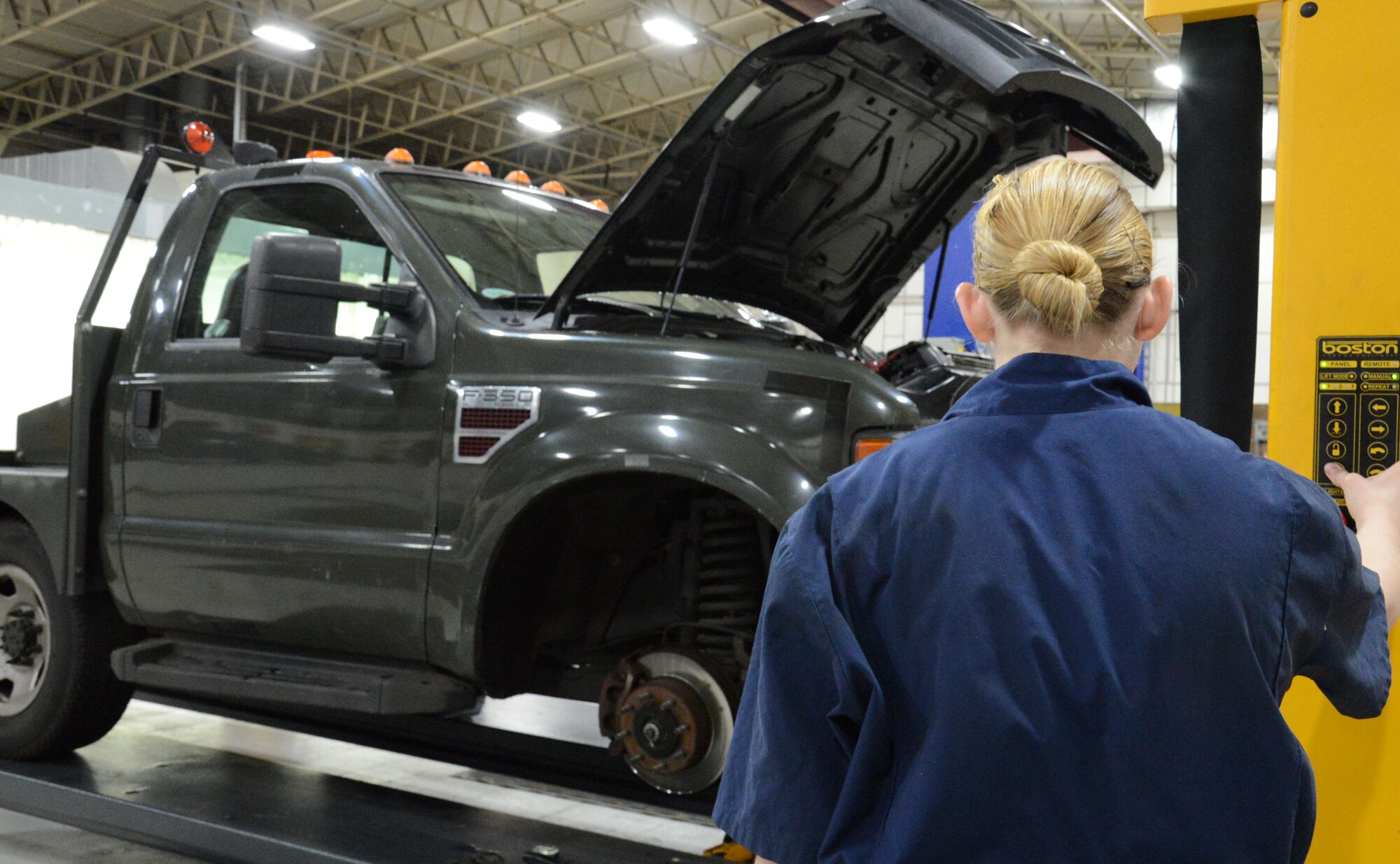 U.S. Air Force Airman 1st Class Carly Reuter, 100th Logistics Readiness Squadron Vehicle Maintenance journeyman from Grangeville, Idaho, uses a vehicle lift to lower a government vehicle prior to an oil change Feb. 4, 2015, on RAF Mildenhall, England. Routine maintenance ensures the vehicle operates effectively. (U.S. Air Force photo by Gina Randall/Released)