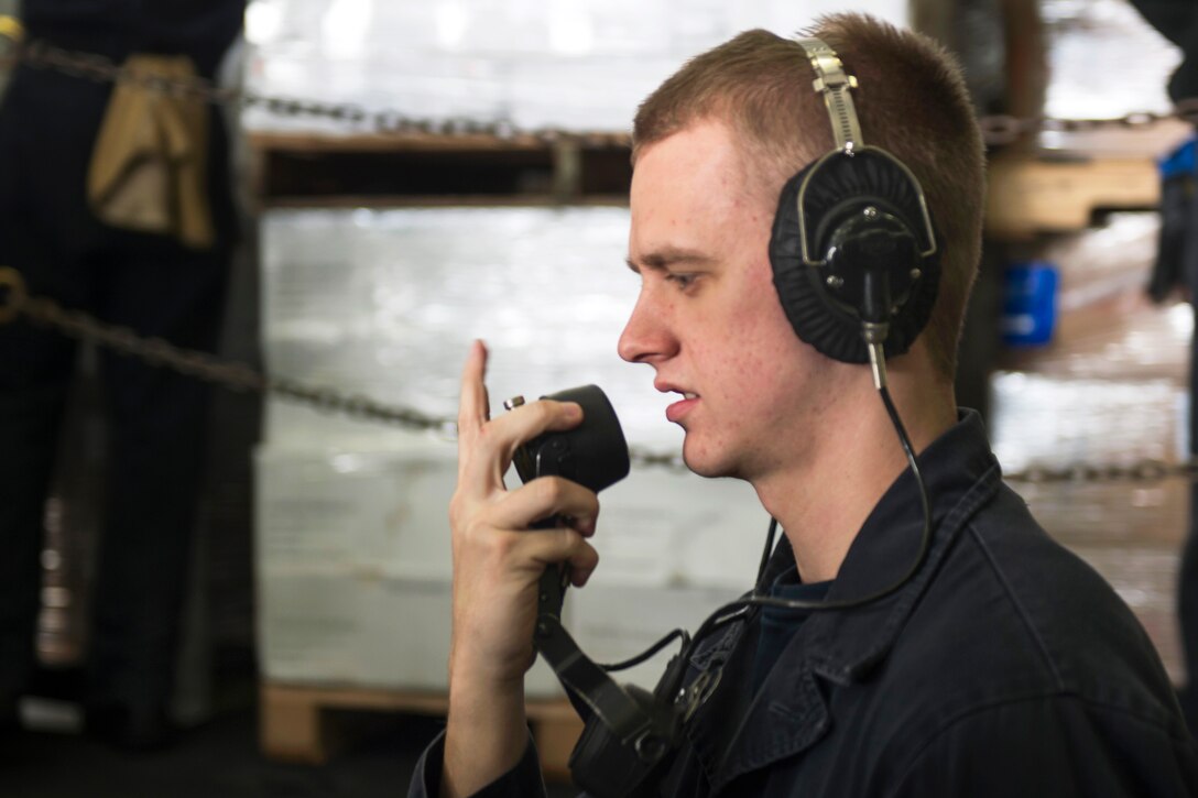 U.S. Navy Seaman Troy Temple uses a sound-powered phone aboard the aircraft carrier USS Carl Vinson in the U.S. 5th Fleet area of responsibility, Feb. 18, 2015. Temple is a damage controlman fireman.