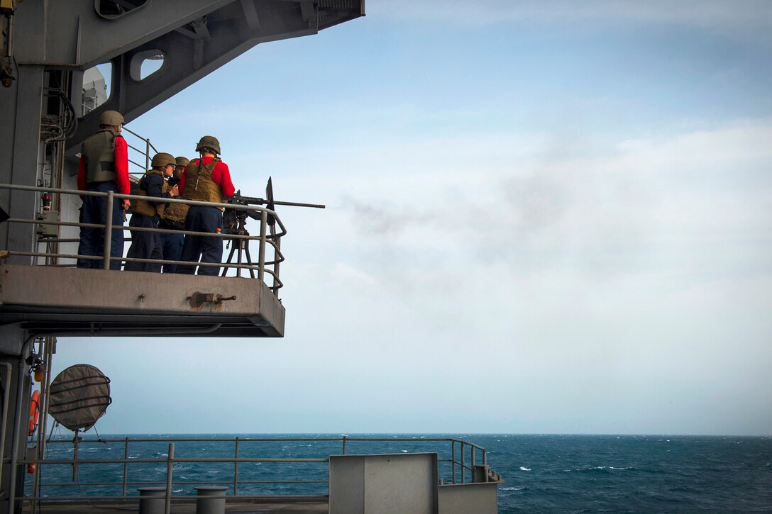 U.S. sailors shoot an M2HB .50-caliber machine gun during a qualification shoot on the fantail of the aircraft carrier USS Carl Vinson in the U.S. 5th Fleet area of responsibility, Feb. 19, 2015.