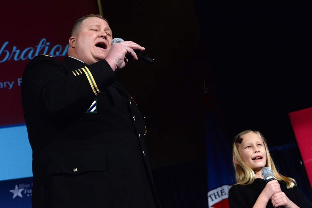 Army Lt. Col. John Lybarger and his daughter Ella sing the national anthem during the Blue Star Families Fifth Anniversary Celebration in Washington, D.C., Feb. 24, 2015. 