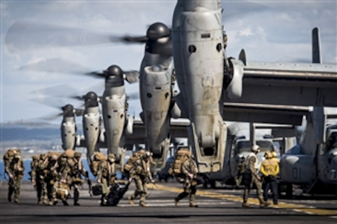 Marines board MV-22 Ospreys before they take off from the flight deck of the amphibious assault ship USS Makin Island off the coast of Camp Pendleton, Calif., Feb. 23, 2015. 