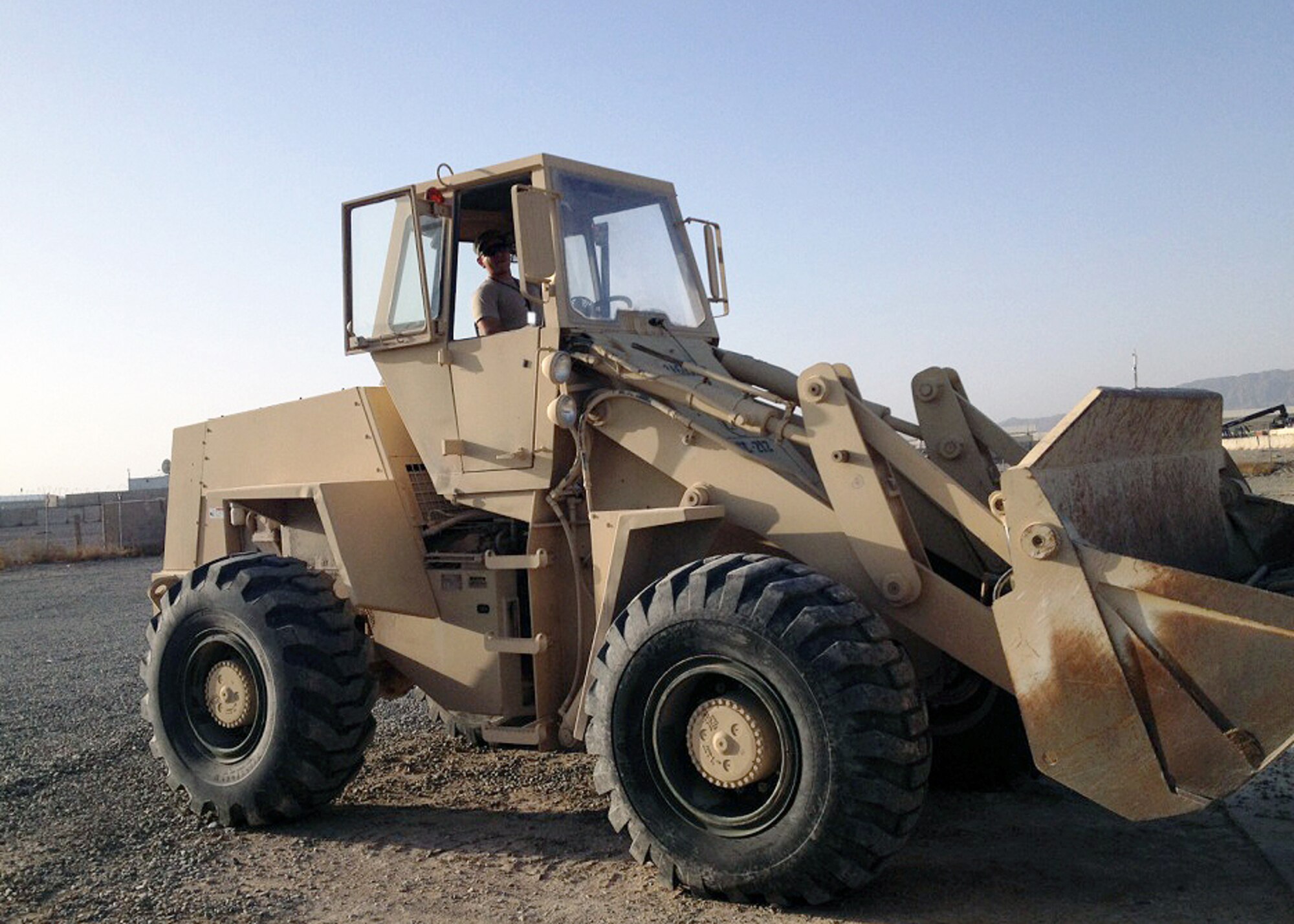 U.S. Air Force Staff Sgt. Gabriel Lara-Ortega, 451st Expeditionary Support Squadron Civil Engineer NCO in charge, loads reclaimed gravel from a vacant camp into a dump truck for use on an access road Feb. 13, 2015 at Kandahar Airfield, Afghanistan. Part of a two-man team, Lara-Ortega and 1st Lt. Tim Lord, 451 CE flight Commander, execute the functions of an average Air Force civil engineer squadron, usually comprised of more than 100 Airmen. (U.S. Air Force courtesy photo/released)