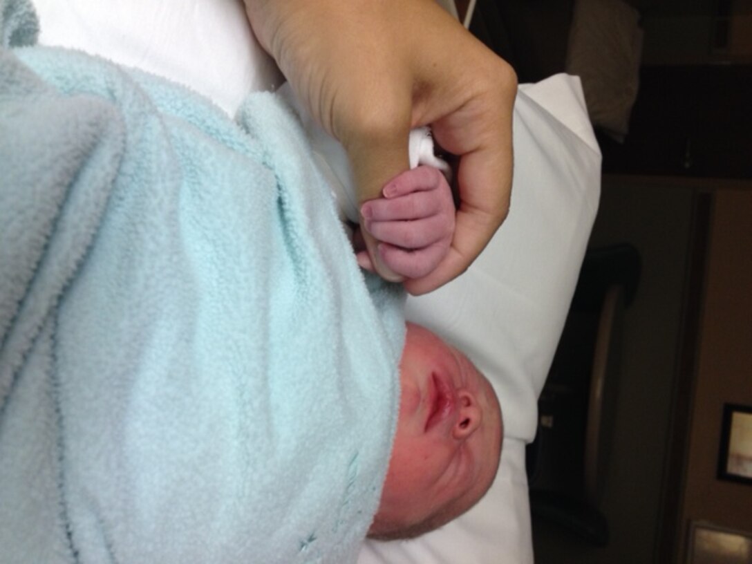 Jamie Steffen, wife of Staff Sgt. Phillip Steffen of the 434th Civil Engineering Squadron at Grissom Air Reserve Base, Indiana, holds her daughter, Nyla Steffen’s, hand just hours after she was born July 21, 2014, in Lutheran Hospital in Ft. Wayne, Indiana. Steffen, the assistant noncommissioned officer in charge of the structures shop at the 434th CES, arrived home from deployment 25 hours after his daughter was born. (Courtesy photo)