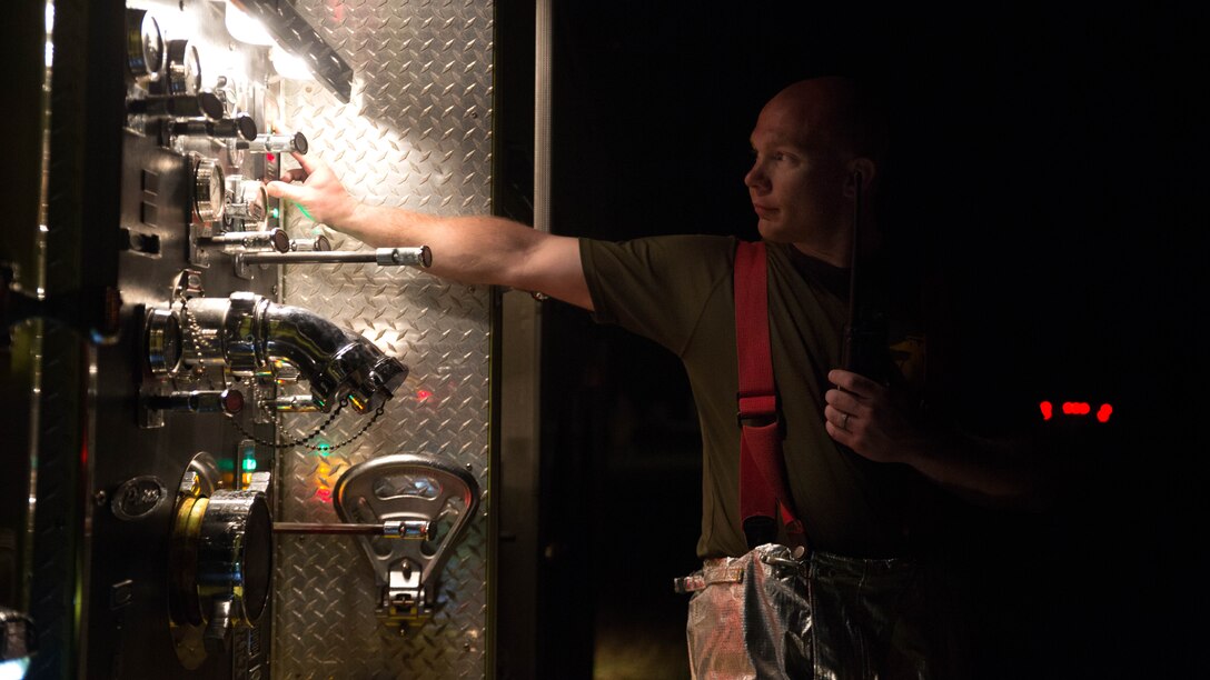 Cpl. Larry W. Danley prepares to shut down equipment following live-burn training Feb. 21 at the training pit on Marine Corps Air Station Futenma. Bulk fuel specialists dispensed fuel into the pit, and a Marine with Aircraft Rescue and Firefighting ignited the fluid. ARFF and bulk fuel specialist Marines then worked together to contain and extinguish the fire while enhancing communication and teamwork.  Danley is a Houston, Texas, native and a truck master with Aircraft Rescue and Firefighting, Headquarters and Headquarters Squadron, MCAS Futenma. 