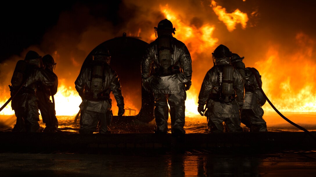 Marines use water to extinguish a fuel fire at Marine Corps Air Station Futenma during live-burn training Feb. 21. Bulk fuel specialists dispensed fuel into the training pit, and a Marine with Aircraft Rescue Firefighting ignited the fluid. The ARFF and bulk fuel specialist Marines then worked together to contain and extinguish the fire while enhancing communication and teamwork. The Marines are with ARFF, Headquarters and Headquarters Squadron, MCAS Futenma, as well as Bulk Fuel Company, 9th Engineer Support Battalion, 3rd Marine Logistics Group, III Marine Expeditionary Force. 