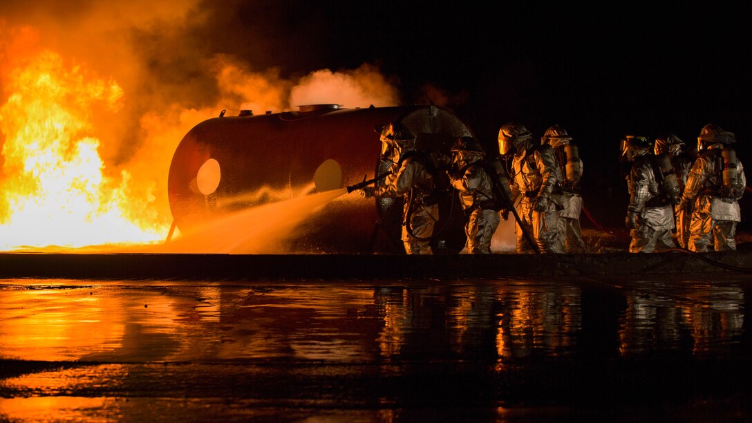 Marines use water to extinguish a fuel fire at Marine Corps Air Station Futenma during live-burn training Feb. 21. Bulk fuel specialists dispensed fuel into the training pit, and a Marine with Aircraft Rescue Firefighting ignited the fluid. ARFF and bulk fuel specialist Marines worked together to contain and extinguish the fire while enhancing communication and teamwork. The Marines are with ARFF, Headquarters and Headquarters Squadron, MCAS Futenma, as well as Bulk Fuel Company, 9th Engineer Support Battalion, 3rd Marine Logistics Group, III Marine Expeditionary Force. 