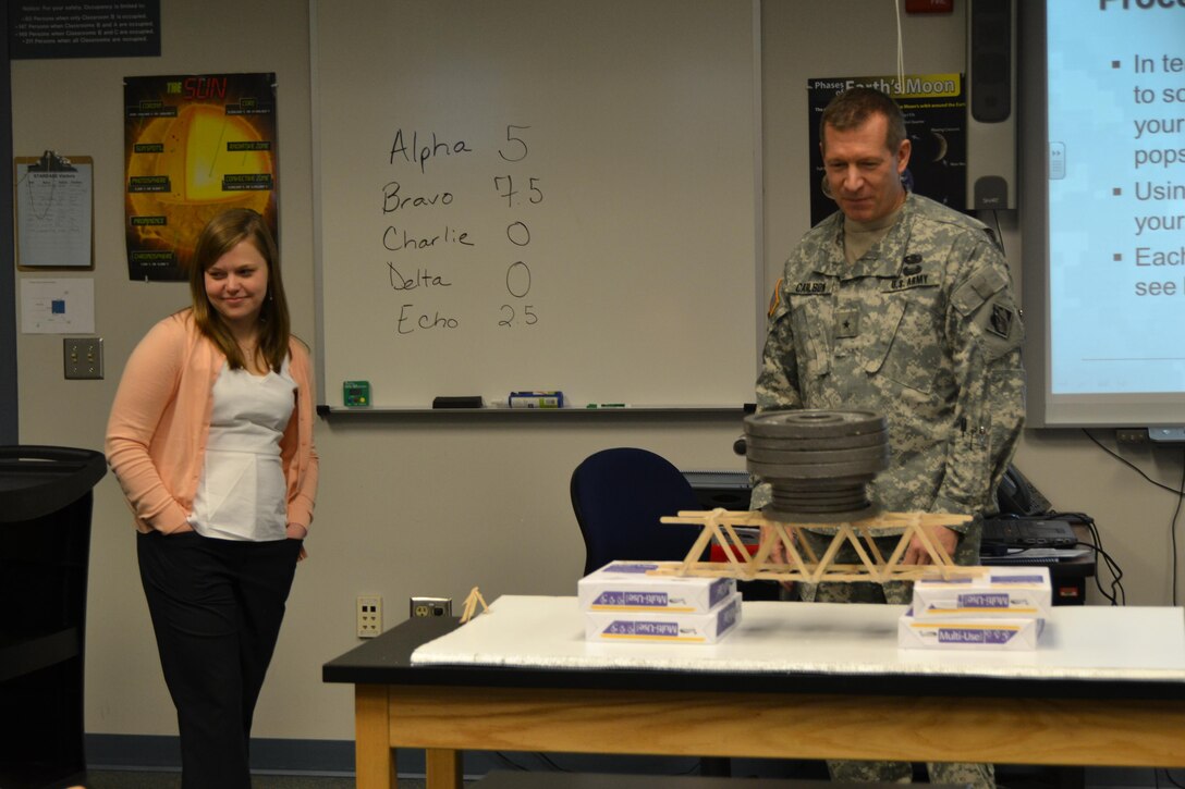WINCHESTER, Va. - Middle East District structural engineer Elizabeth Prusch beams after Brig. Gen. Robert Carlson added the final weight to her bridge, for a grand total of 60 pounds. The students determined she must have used magic to make it so strong. 