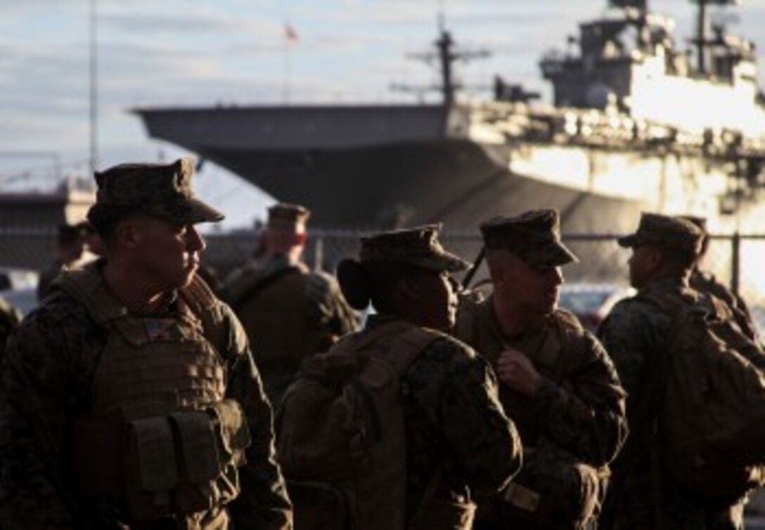 U.S. Marines with the 15th Marine Expeditionary Unit prepare to embark onto the USS Essex (LHD 2) to begin Amphibious Squadron/Marine Expeditionary Unit Integration Training (PMINT) aboard Naval Base San Diego Feb. 22, 2015. The 15th MEU is embarked aboard the three ships of the Essex Amphibious Ready Group - the USS Essex, USS Anchorage (LPD 23), and USS Rushmore (LSD 47) – during PMINT to continue integrating and training with the PHIBRON and ship staffs as they prepare for deployment later this spring. (U.S. Marine Corps photo by Cpl. Elize McKelvey/Released)