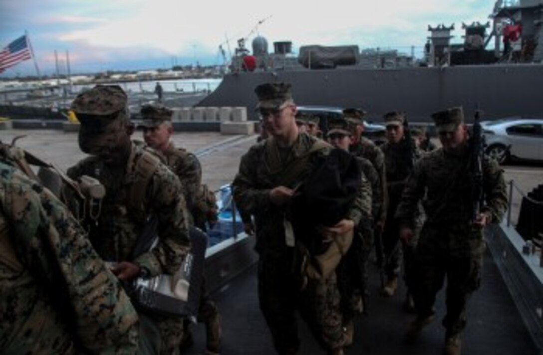 U.S. Marines with the 15th Marine Expeditionary Unit prepare to embark onto the USS Essex (LHD 2) to begin Amphibious Squadron/Marine Expeditionary Unit Integration Training (PMINT) aboard Naval Base San Diego Feb. 22, 2015. The 15th MEU is embarked aboard the three ships of the Essex Amphibious Ready Group - the USS Essex, USS Anchorage (LPD 23), and USS Rushmore (LSD 47) – during PMINT to continue integrating and training with the PHIBRON and ship staffs as they prepare for deployment later this spring. (U.S. Marine Corps photo by Cpl. Elize McKelvey/Released)