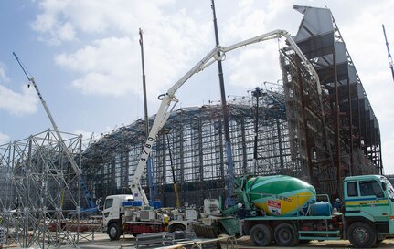 In this file photo, construction is nearly halfway complete on a project to relocate U.S. Navy aircraft operations on Kadena Air Base, Japan. Two aircraft hangars are being raised near the center of the base’s runway. The hangars will require less energy to operate, support the U.S. Navy’s current inventory of aircraft and reduce the amount of noise leaving Kadena Air Base.  