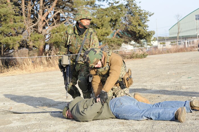 HACHINOHE, Japan (Feb. 24, 2014) - Builder 3rd Class Joshua Donahoe, from Huntington, W. V., assigned to Naval Air Facility (NAF) Misawa's Public Works Department, detains a Sailor assuming the role of an armed shooter while a member of the Japan Ground Self-Defense Force provides extra security during bilateral security training at Camp Hachinohe. This training was conducted to familiarize NAF Misawa and JGSDF security forces with each other's communication and security techniques. 