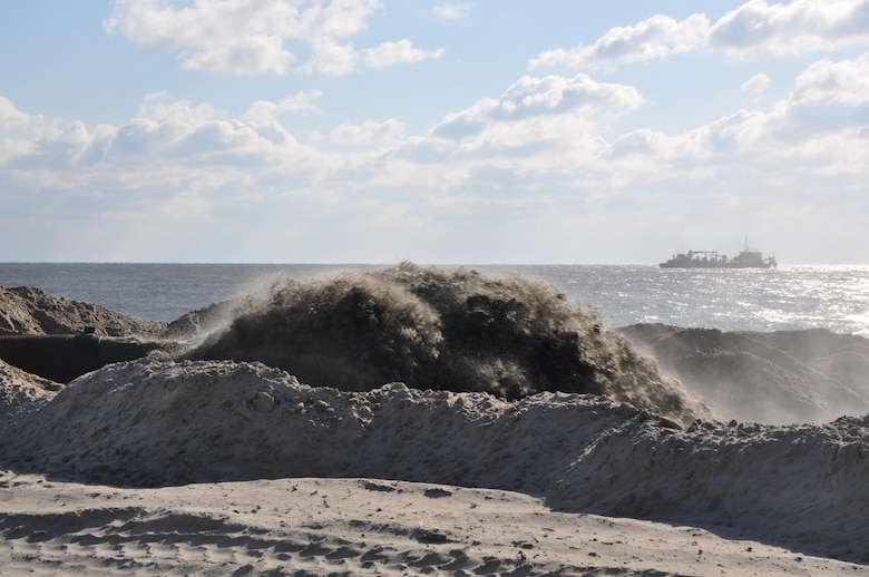 A mixture of sand and water pumping onshore at Westhampton Beach, New York, November 21, 2014. A dredge (background) collects sand from an approved offshore borrow site and  transports it to land via large underwater pipes. The Army Corps of Engineers, New York District, placed nearly 1 million cubic yards of sand for the Westhampton Beach Interim Project providing coastal storm risk reduction for nearly 4 miles of shoreline from Westhampton Beach to Cupsogue Beach County Park on Long Island’s south shore. Work included berm and dune restoration, tapering an existing groin, and constructing a new groin. The project was completed late 2014. 