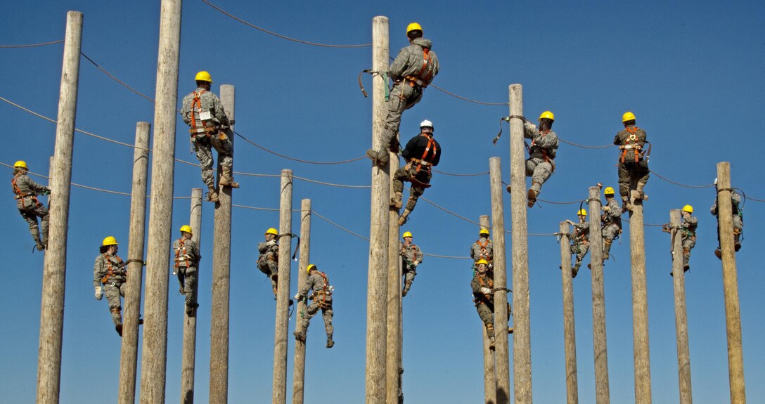 Students of the 364th Training Squadron's electrical systems course practice climbing power poles as part of a familiarization and trust exercise with the safety equipment Feb. 3, 2015, at Sheppard Air Force Base, Texas. They spent an extended period suspended to simulate a lengthy installation or repair as part of the training. (U.S. Air Force photo/Danny Webb)