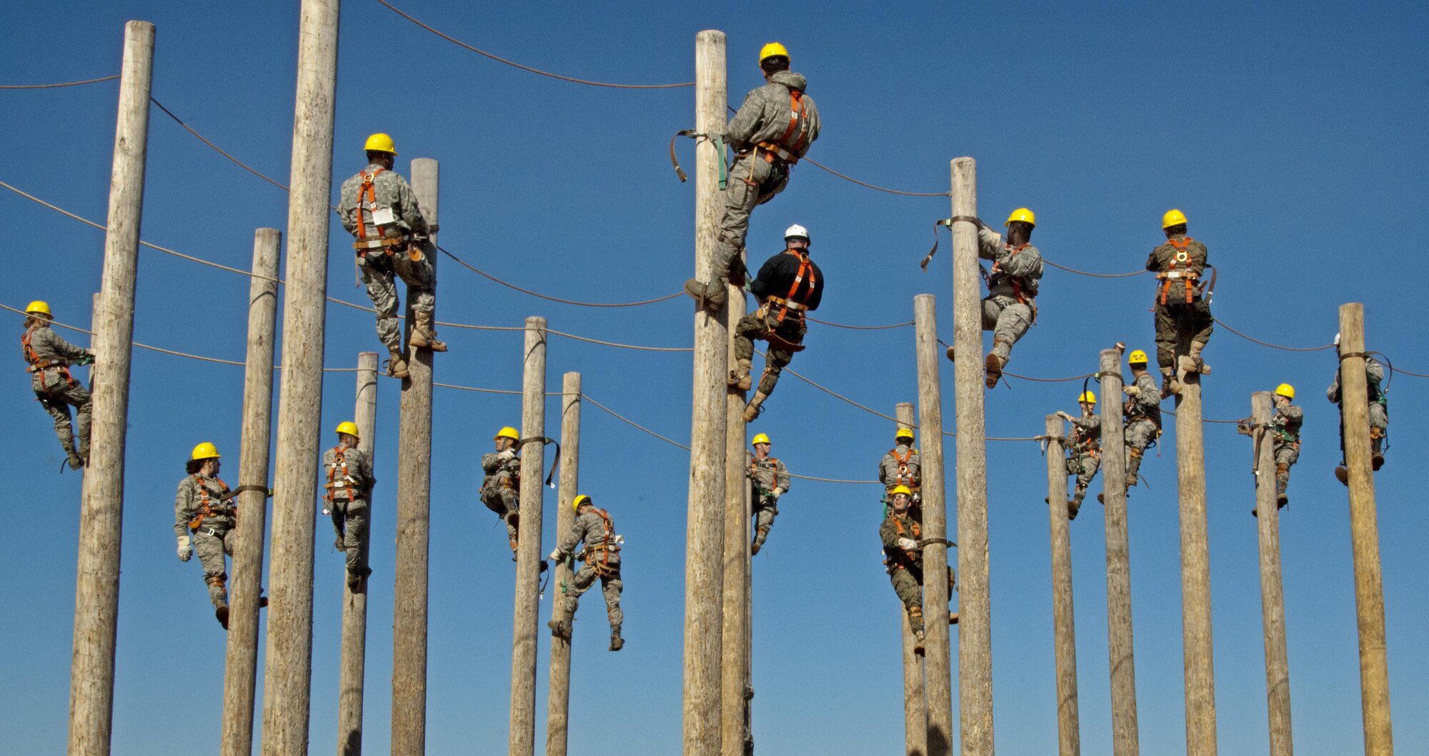 Students of the 364th Training Squadron's electrical systems course practice climbing power poles as part of a familiarization and trust exercise with the safety equipment Feb. 3, 2015, at Sheppard Air Force Base, Texas. They spent an extended period suspended to simulate a lengthy installation or repair as part of the training. (U.S. Air Force photo/Danny Webb)