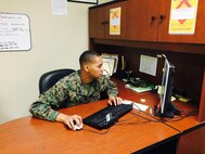 PFC James W. Holiday, a Customer service Administrative clerk making Awards, publishing the morning report for Headquarters Company, MCCES