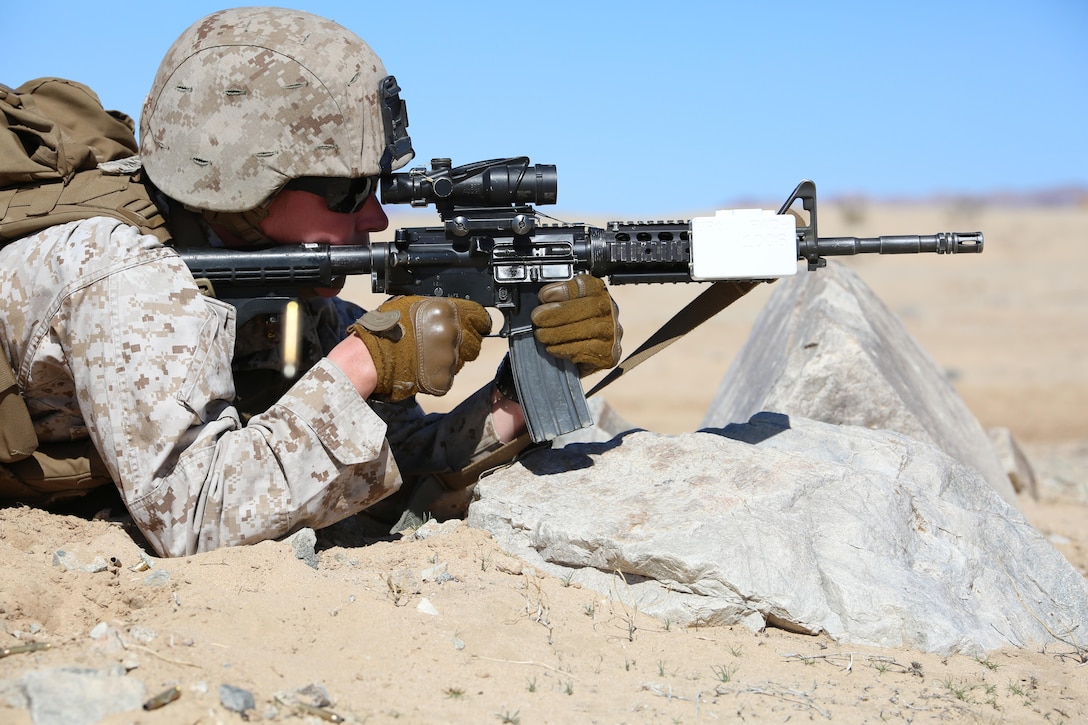 Sgt. Kelly Brown, team leader with Provisional Rifle Platoon, Company A, Ground Combat Element Integrated Task Force, sends rounds downrange with the M4 Modular Weapon System during a target confirmation at Range 107, Marine Corps Air Ground Combat Center Twentynine Palms, California, Feb. 26, 2015, in preparation for the upcoming assessment. From October 2014 to July 2015, the GCEITF will conduct individual and collective level skills training in designated ground combat arms occupational specialties in order to facilitate the standards-based assessment of the physical performance of Marines in a simulated operating environment performing specific ground combat arms tasks. (U.S. Marine Corps photo by Sgt. Alicia R. Leaders/Released)