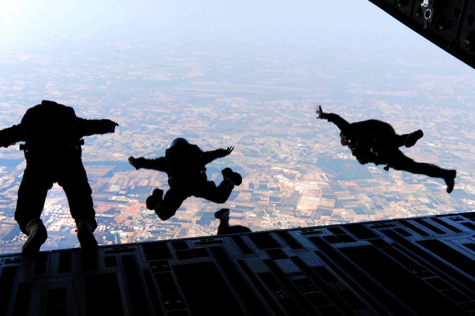 Members with Indian Army's 2nd Parachute Regiment (Special Forces), and National Security Guard jump from a Pacific Air Forces C-17 Globemaster III for a parachuting demonstration at Air Force Station Yelahanka, Bengaluru, India, Feb. 20, 2015. Aero India is India's premier aerospace exhibition and airshow and allows the United States to demonstrate its commitment to the security of the Indo-Asia-Pacific region and showcase defense aircraft and equipment, which ultimately contributes toward better regional cooperation and tactical compatibility with other countries.  This year marks the 10th iteration of Aero India since its inception in 1996.  (U.S. Air Force photo by Airman 1st Class Stephen G.Eigel/Released)
