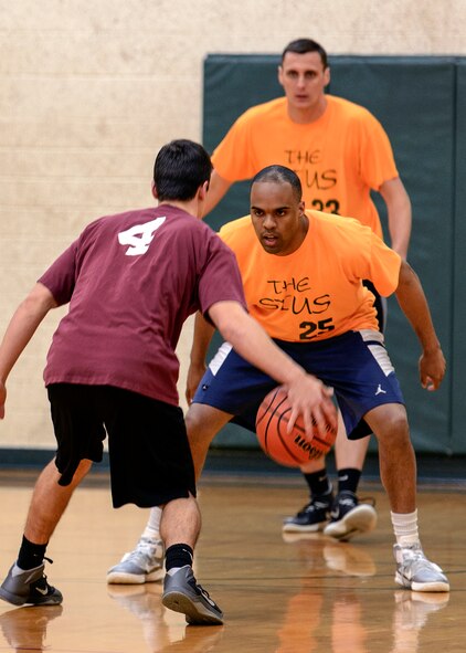 VANCE AIR FORCE BASE, Okla. -- 71st Student Squadron's Kyle Green (25) covers a 33rd Flying Training Squadron guard as teammate Tim Martinelli looks on at Bradley Fitness and Sports Center, Feb. 24. Green and Martinelli combined for 24 rebounds in a 71-22 win. (U.S. Air Force photo / David Poe)