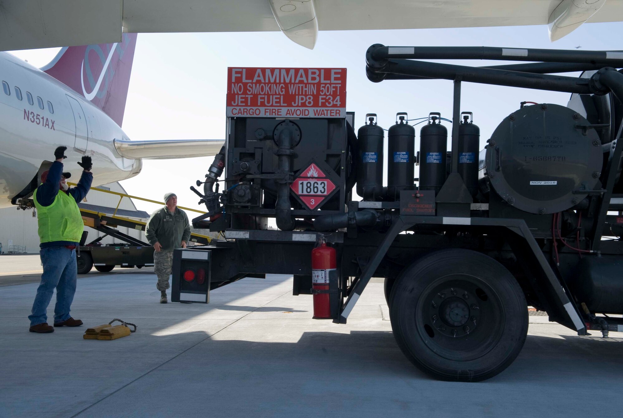 U.S. Department of Defense contractor Mark Ringquist, ground handler, directs the driver of an R-12 fuel servicing vehicle to the correct fueling position at Misawa Air Base, Japan, Feb. 24, 2015. The R-12 fuel servicing vehicle is used to transfer fuel directly from a newly installed underground fuel system to aircraft. (U.S. Air Force photo by Airman 1st Class Jordyn Rucker/Released)