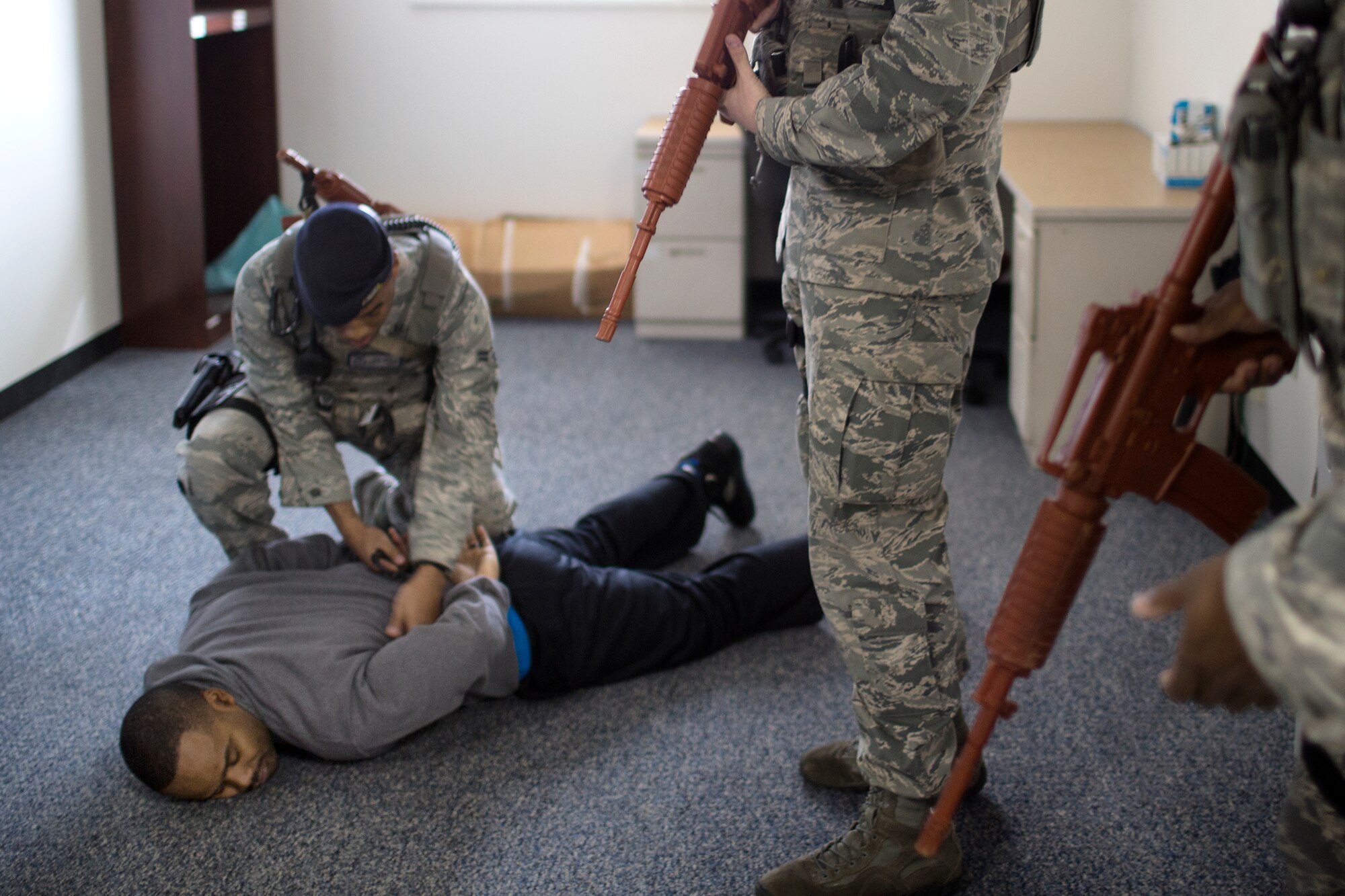Airman 1st Class Jamal Wilson, 374th Security Force Squadron patrolman, checks a simulated active shooter after detaining him at the Defense Finance and Accounting Service Japan facility at Yokota Air Base, Japan, Feb. 25, 2015. The active shooter training scenario tested and validated DFAS’ force protection plans, occupant emergency plan, and evacuation and accountability procedures. (U.S. Air Force photo by Osakabe Yasuo/Released)  