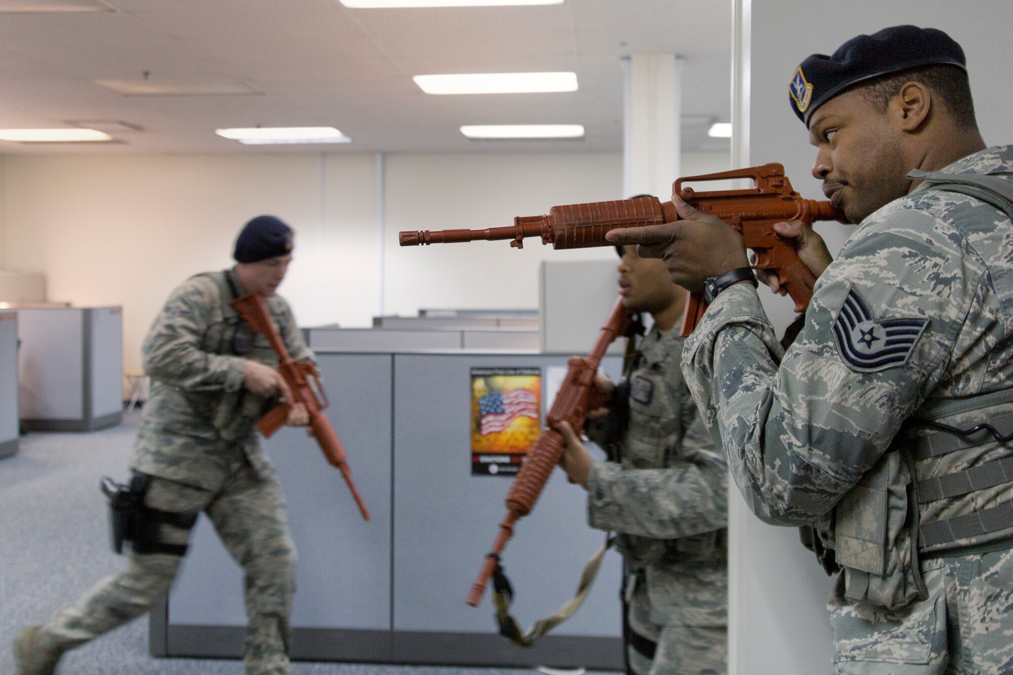 (Right) Tech. Sgt. Kandall Emile, 374th Security Forces Squadron patrolman, covers his team during an active shooter training scenario at the Defense Finance and Accounting Service Japan facility at Yokota Air Base, Japan, Feb. 25, 2015. The scenario tested and validated DFAS’ force protection plans, occupant emergency plan, and evacuation and accountability procedures. (U.S. Air Force photo by Osakabe Yasuo/Released)  