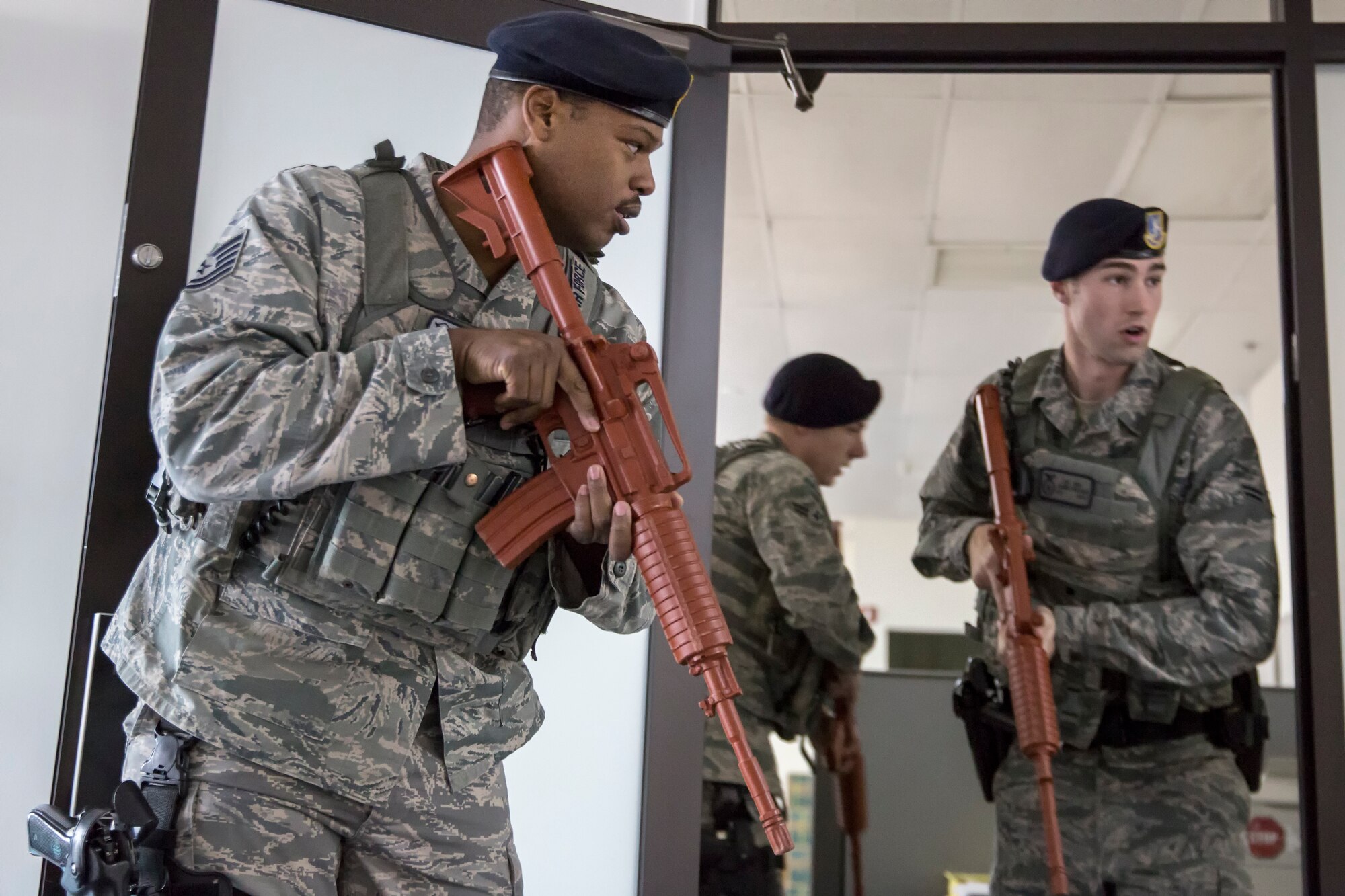 (Left) Tech. Sgt. Kandall Emile, 374th Security Forces Squadron patrolman, secures and leads his team during an active shooter training scenario at the Defense Finance and Accounting Service Japan facility, Yokota Air Base, Japan, Feb. 25, 2015. The scenario tested and validated DFAS’ force protection plans, occupant emergency plan, and evacuation and accountability procedures. (U.S. Air Force photo by Osakabe Yasuo/Released)  