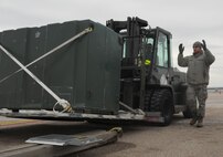 Staff Sgt. Ronald West, 22nd Logistics Readiness Squadron air transportation specialist, directs Senior Airman Brian Bautista, 22nd LRS aircraft parts store journeyman, to lower a cargo pallet onto a scale, Feb. 23, 2015 at McConnell Air Force Base, Kan. The pallet was weighed before being loaded onto an aircraft. The 22nd LRS is responsible for moving McConnell’s personnel and supplies in order to support the refueling mission. (U.S. Air Force photo by Airman 1st Class Tara Fadenrecht)